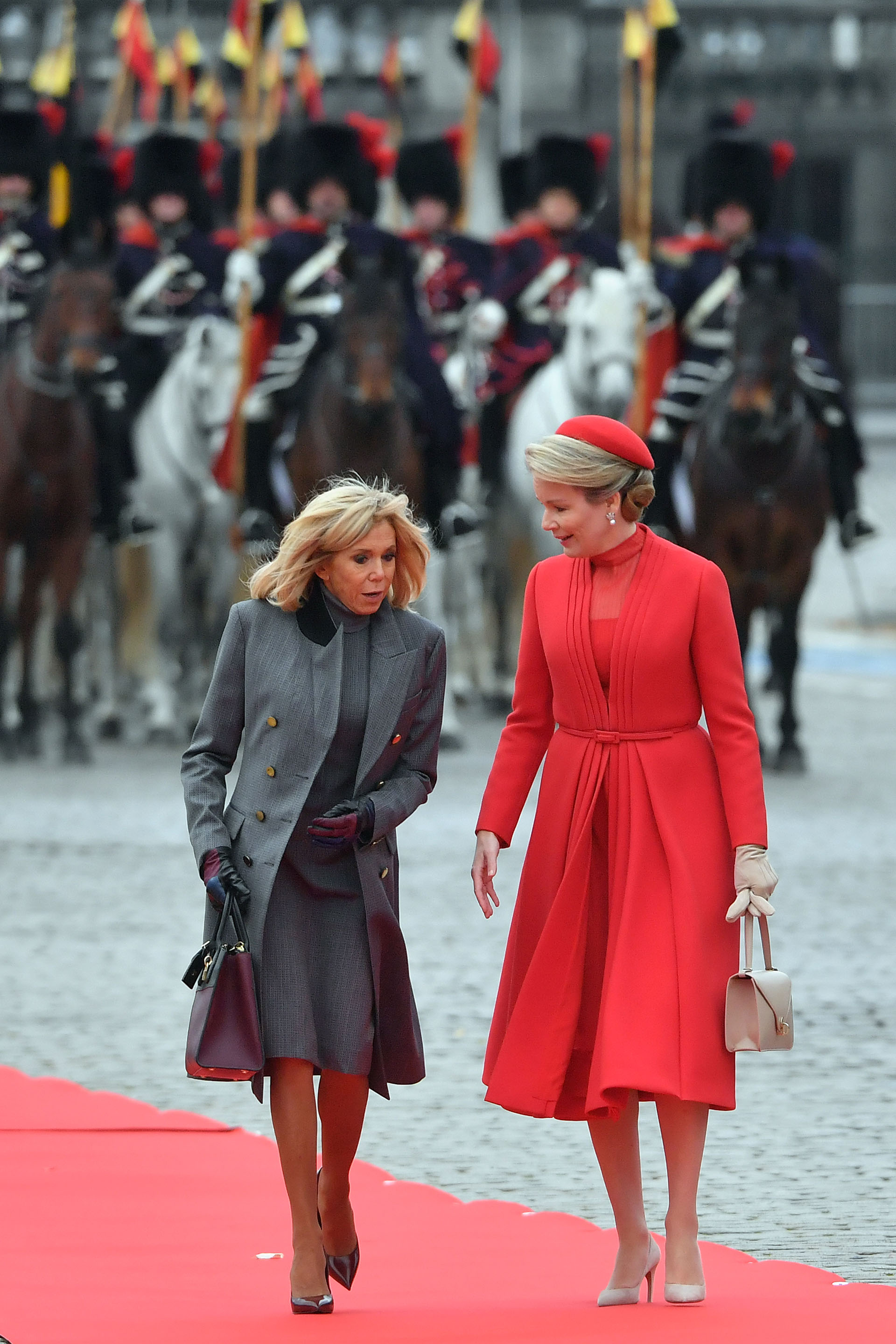 Brigitte Macron se decantó por el color gris oscuro, luciendo un vestido y un tapado con botones dorados