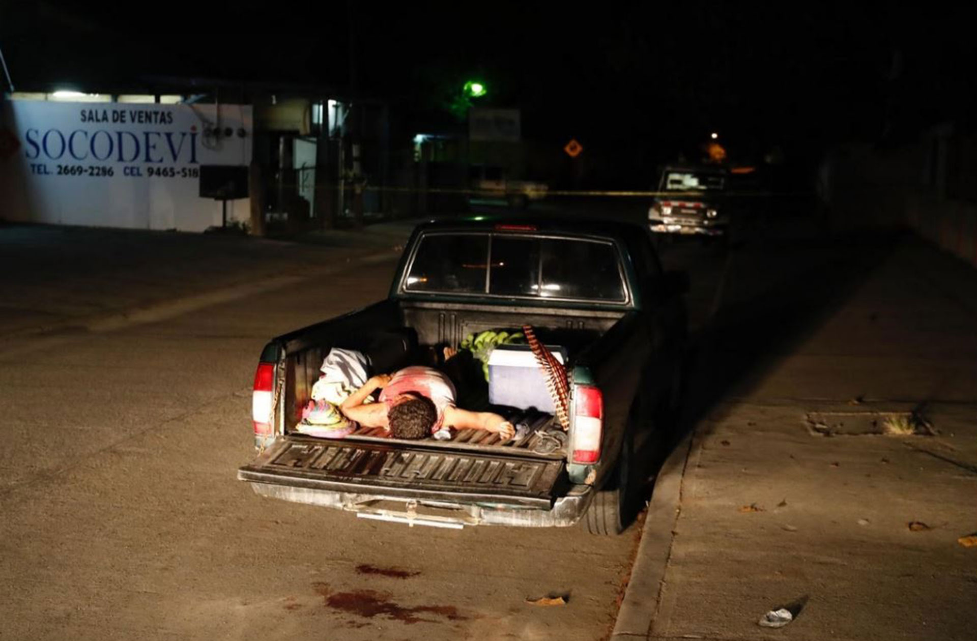 El cuerpo de un hombre muerto por la violencia de pandillas en la caja de un vehículo