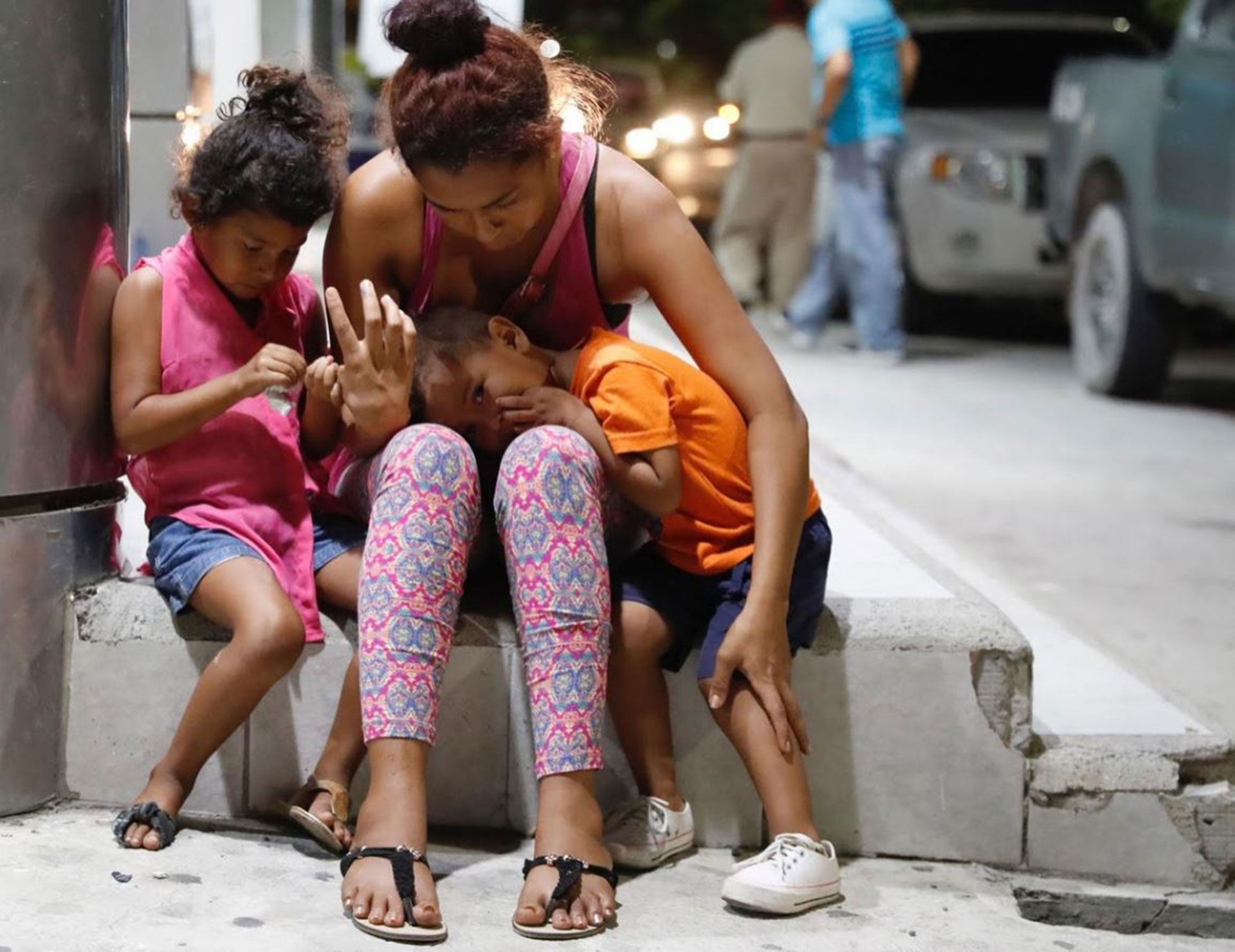 Una mujer llora con sus hijos tras la muerte de su marido