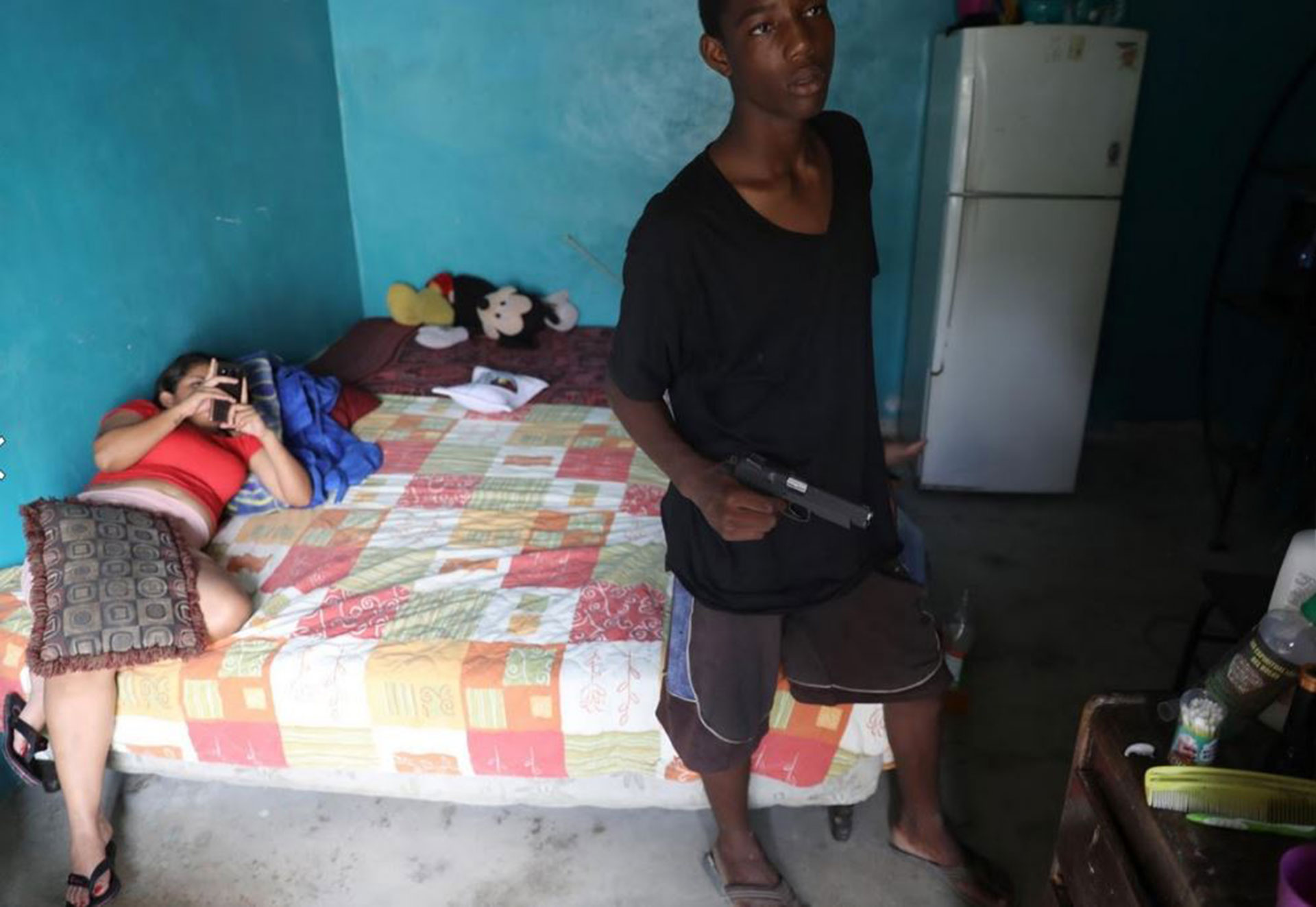 Un miembro de la pandilla Barrio 18 en su casa fotografiado por su mujer