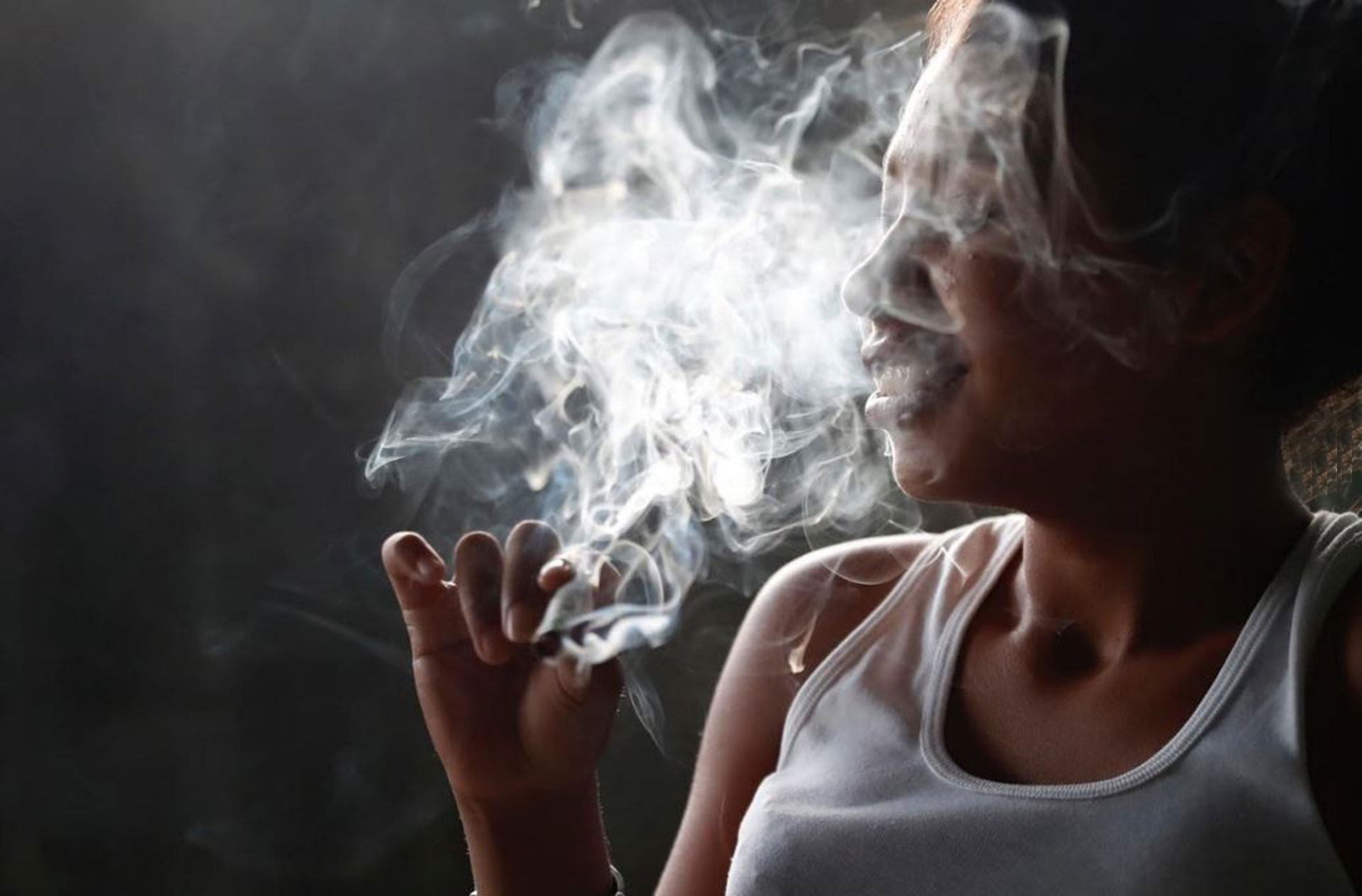 Una mujer fuma marihuana que le compró a los pandilleros