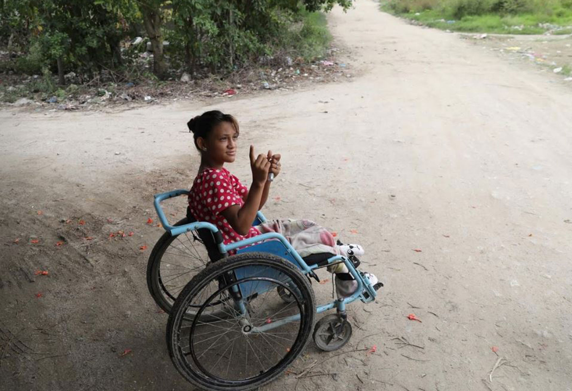 Una mujer en silla de rueda es fotografiada en un lugar donde se pelean pandillas