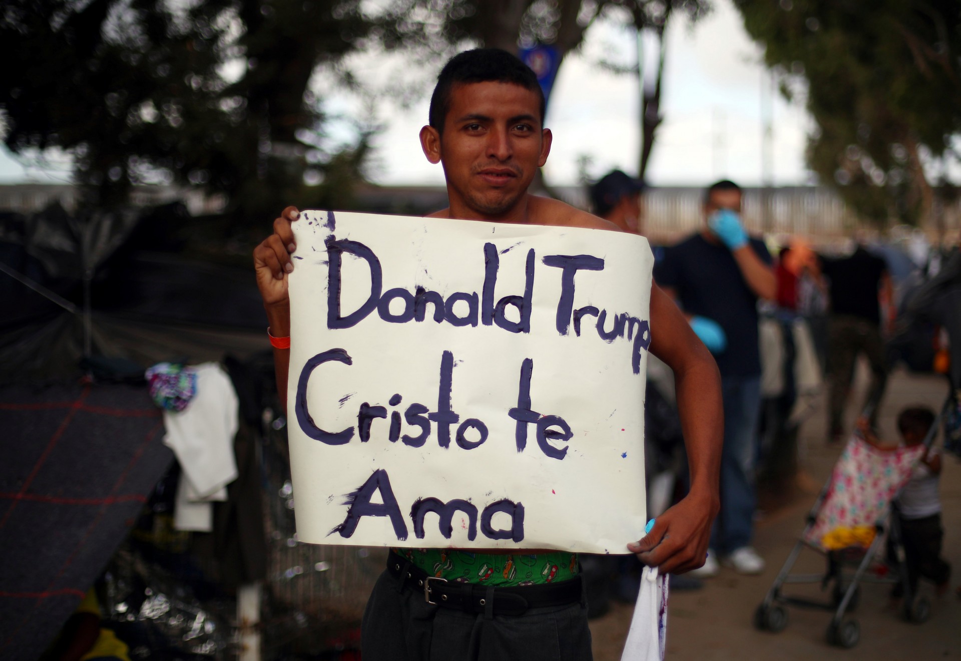 Un migrante centroamericano con un cartel dedicado a Donald Trump (REUTERS/Hannah McKay)