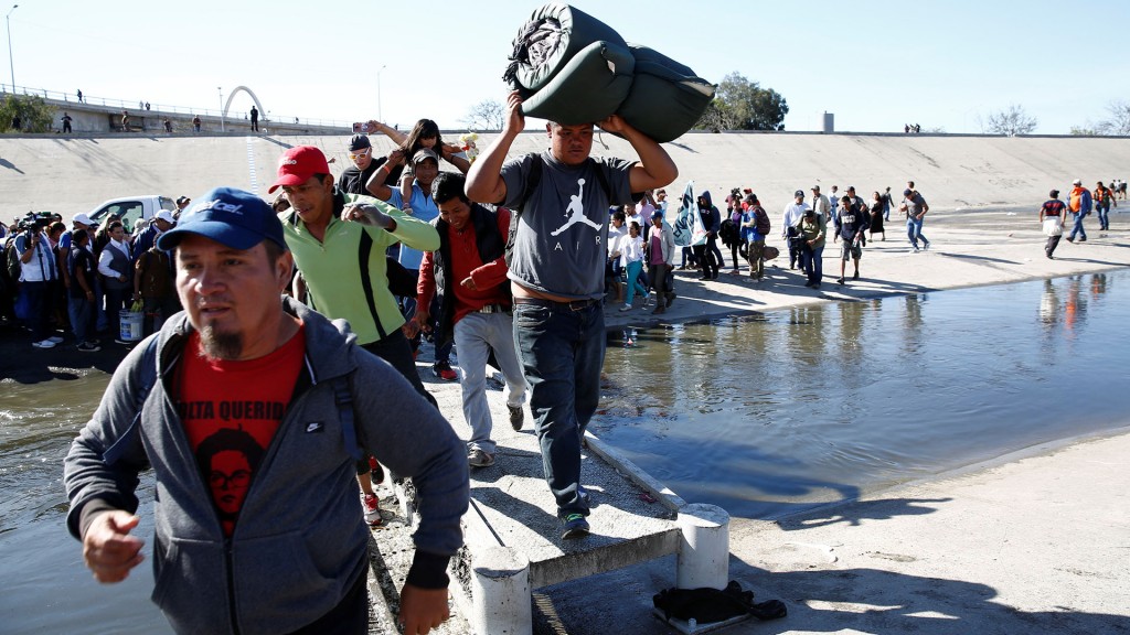 Migrants, part of a caravan of thousands traveling from Central America en route to the United States, make their way to cross Tijuana river near the border wall between the U.S. and Mexico in Tijuana, Mexico November 25, 2018. REUTERS/Kim Kyung-Hoon