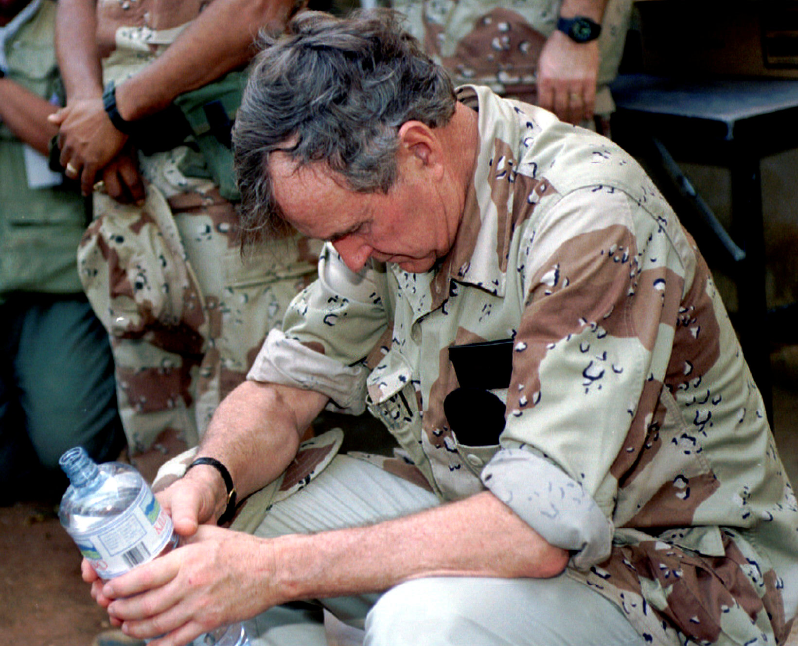 El ex presidente George H.W. Bush descansa mientras sostiene una botella de agua durante su visita a las tropas norteamericanas en Somalia el 2 de enero de 1993. (REUTERS/Rick Wilking)