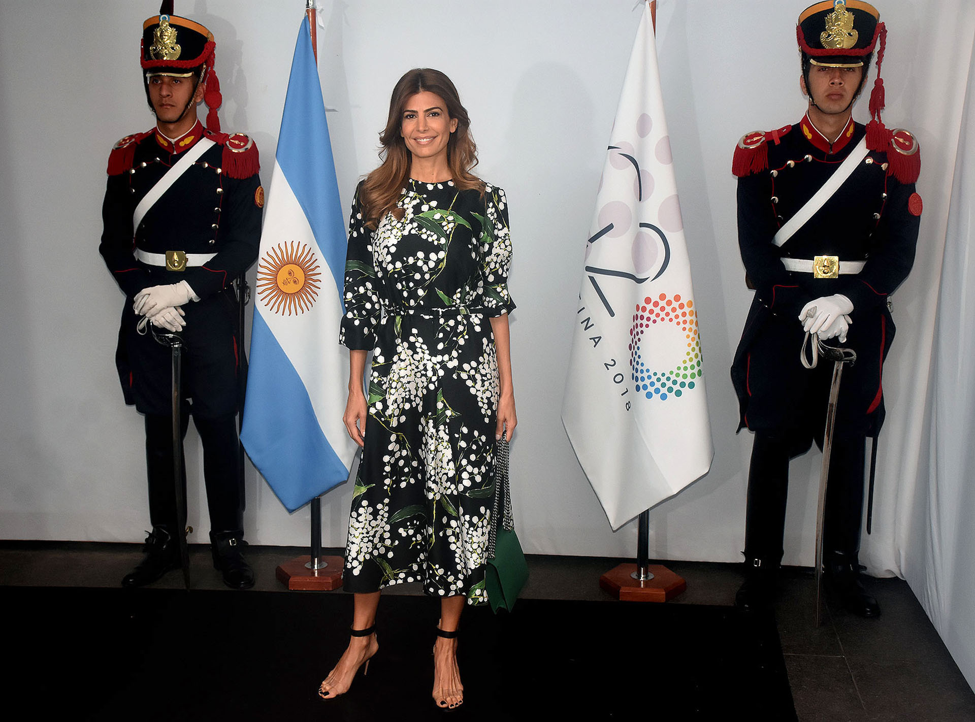 La primera dama Juliana Awada, la gran anfitriona de todas las reuniones entre mujeres tuvo un rol central y lo cumplió con solvencia. Condujo el recorrido por el Malba con un diseño negro con estampado abstracto de corte midi con mangas abuchonadas. Completó su look con una cartera de la última colección de Louis Vuitton en verde y sandalias negras con detalles de pvc. Su beauty look fue pelo suelto con ondas y make up resaltando los labios rosados