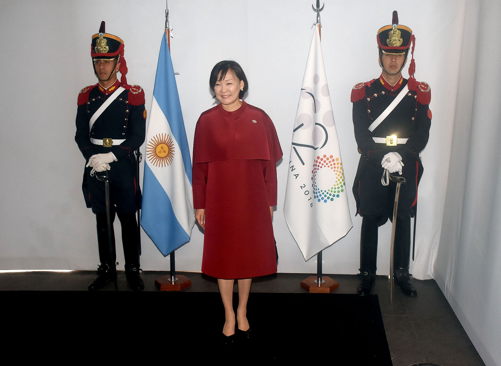 Akie Abe, esposa del primer ministro de Japón, apostó al total red. Un vestido recto a la rodilla con capa. Para los pies lució loafers en negro acharoladas. Los accesorios de la primera dama del país asiático fueron unos delicados aros de brillantes
