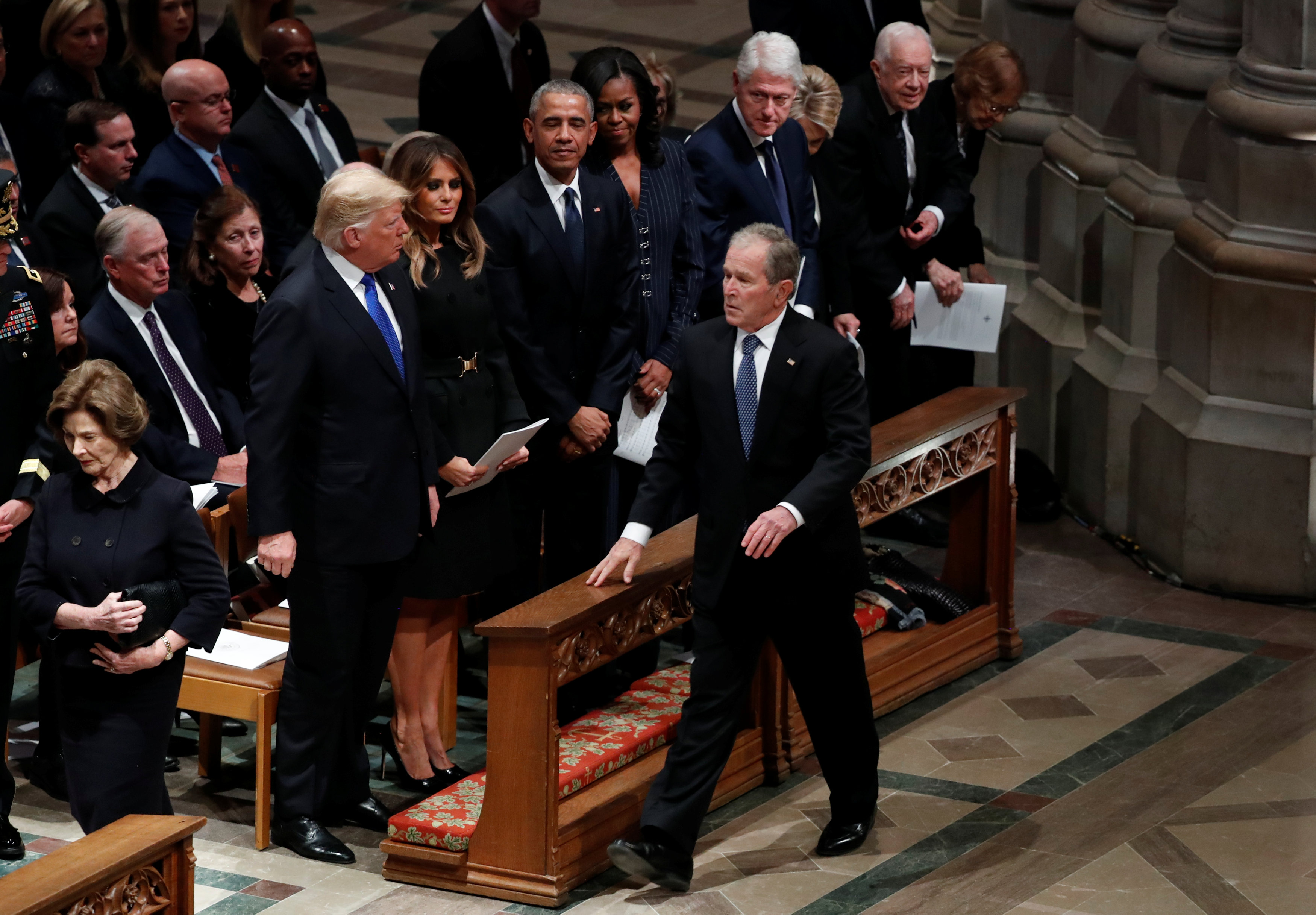 El presidente George W. Bush pasa por delante del presidente Donald Trump y la primera dama Melania Trump, así como del ex presidente Barack Obama, la ex primera dama Michelle Obama, el ex presidente Bill Clinton, la ex primera dama Hillary Clinton, el ex presidente Jimmy Carter y la ex primera dama Rosalynn Carter cuando llega al funeral de su padre, el ex presidente George H.W. Bush, en la Catedral Nacional de Washington, en Washington, EE.UU., el 5 de diciembre de 2018. (Reuters)