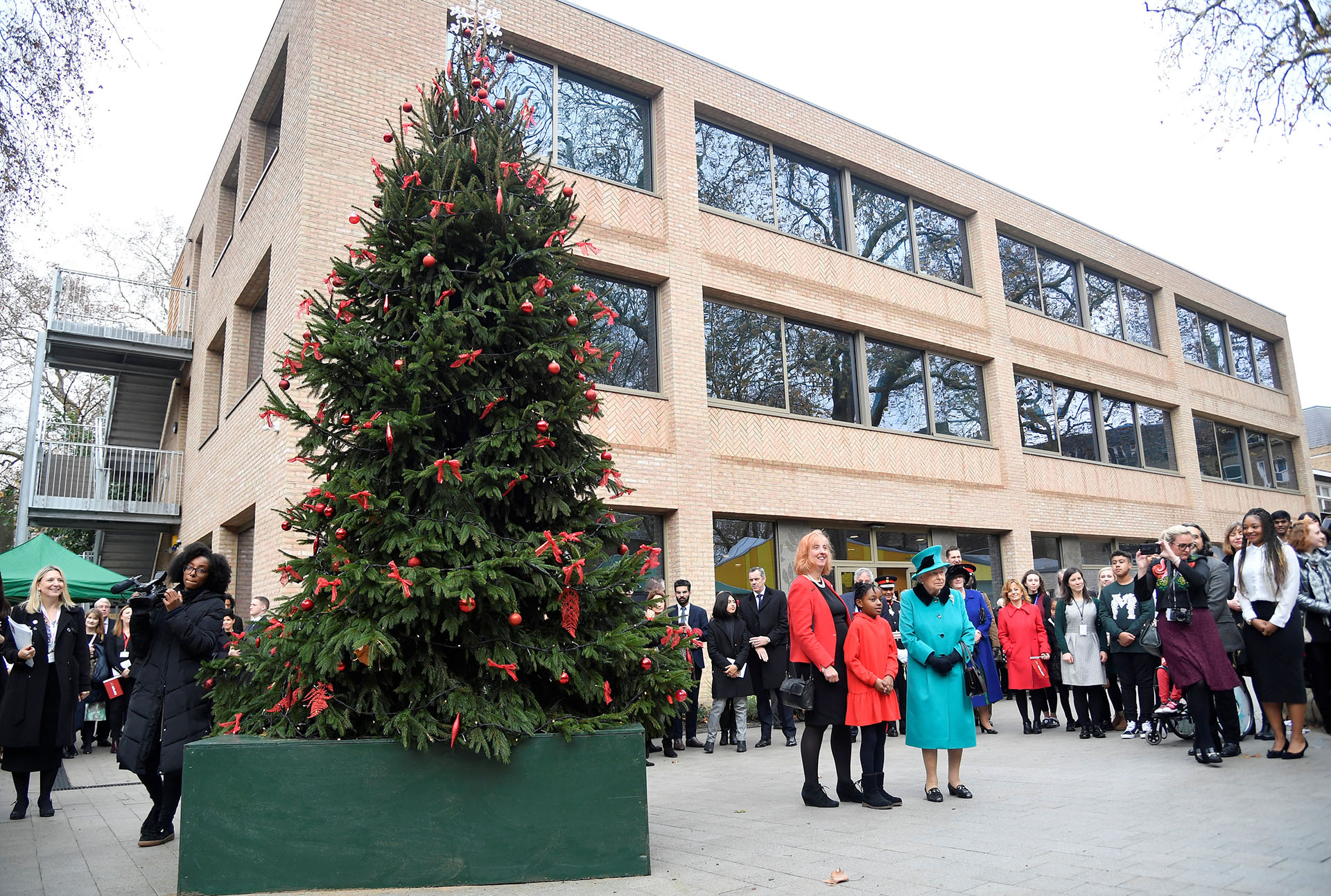 LONDRES, GRAN BRETAÑA. La reina británica Elizabeth, Shylah Gordon y Coram, CEO Carol Homden junto al árbol de navidad de caridad en Londres