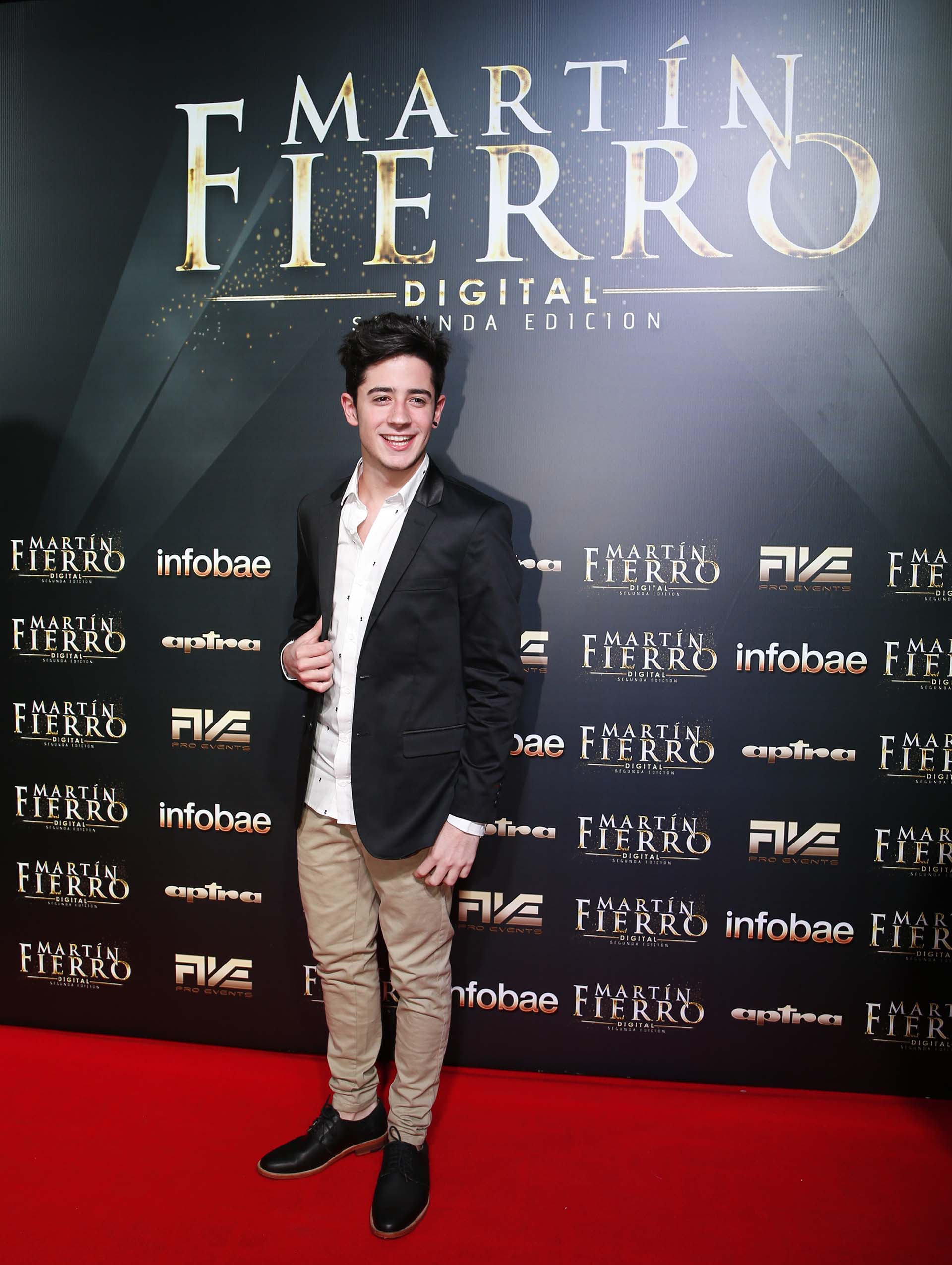 El youtuber Kevsho con saco de esmoquin negro, camisa blanca con dibujos, pantalón de gabardina y zapatos de cuero negro