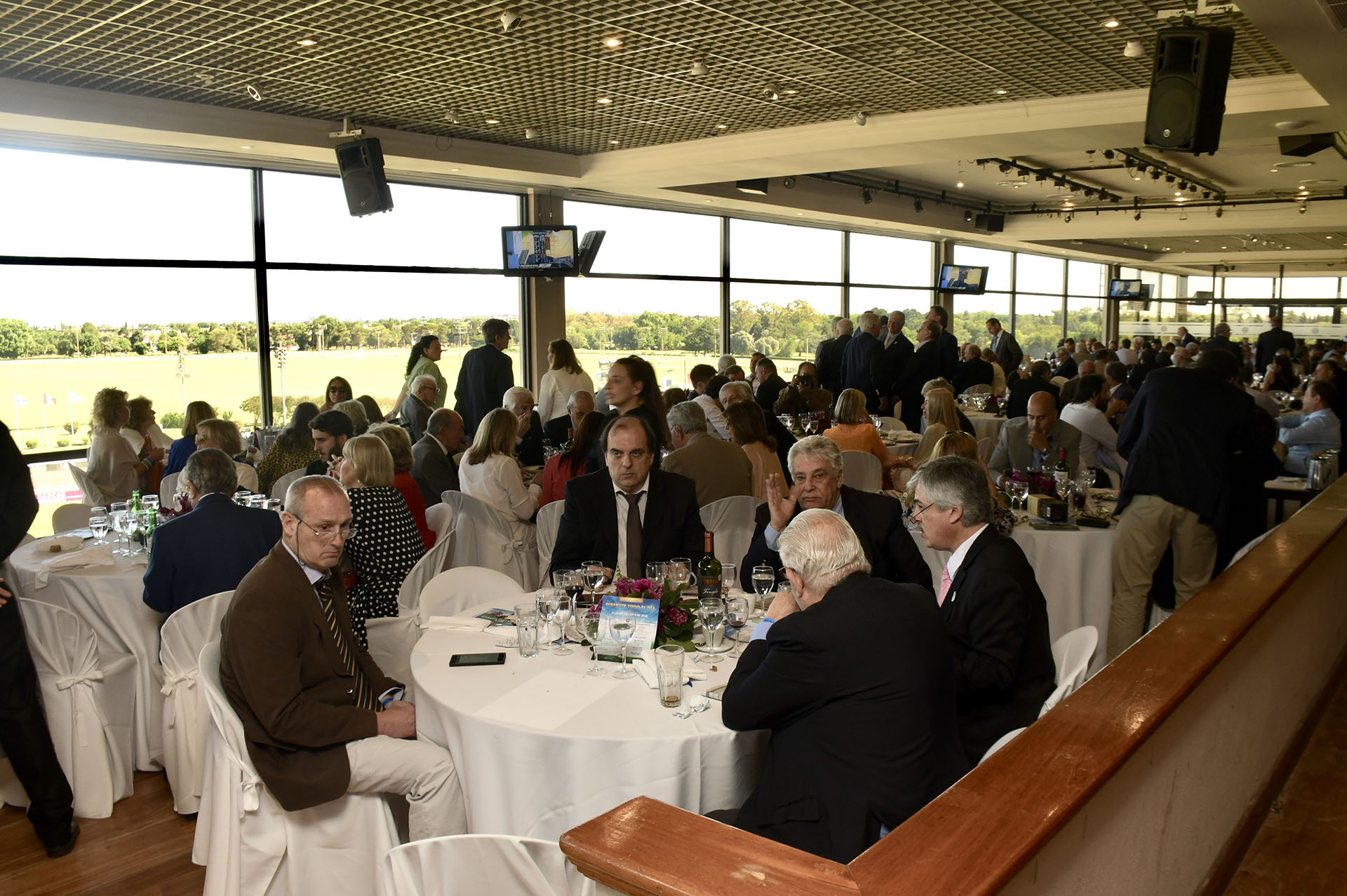 En el cuarto piso de las tribunas del Hipódromo de San Isidro estaba el restaurante con vistas privilegiadas hacia la pista. Televisores con transmisión para poder ver de cerca si sus apuestas eran los ganadores. El dress code para almorzar era elegante. Ellos con traje de saco y corbata y ellas con vestidos y trajes. Muchas mujeres complementaron sus outfits con gafas de sol y sombreros