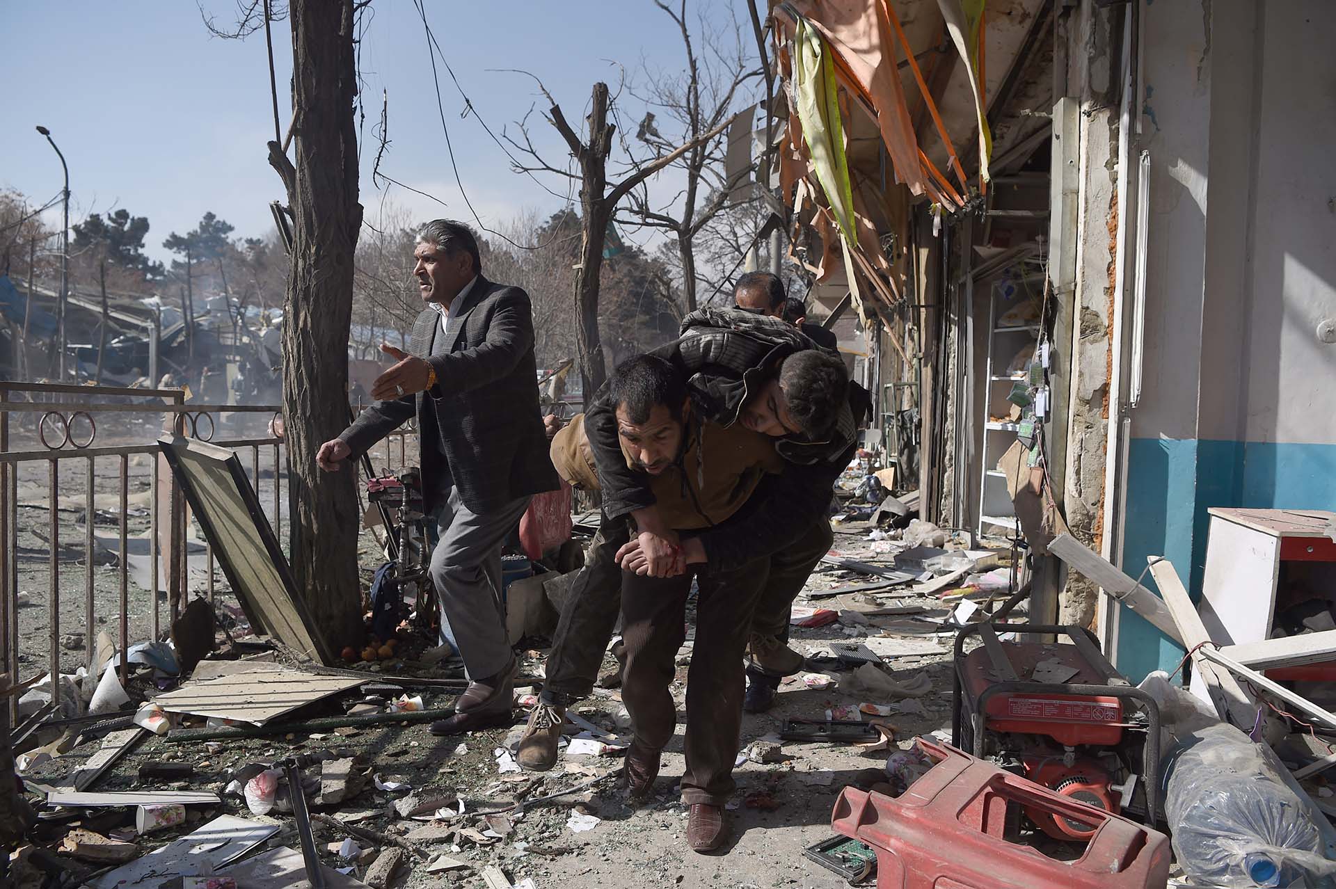 Voluntarios afganos cargan el cuerpo de una víctima de un coche bomba que explotó frente al Ministerio del Interior en Kabul el 27 de enero