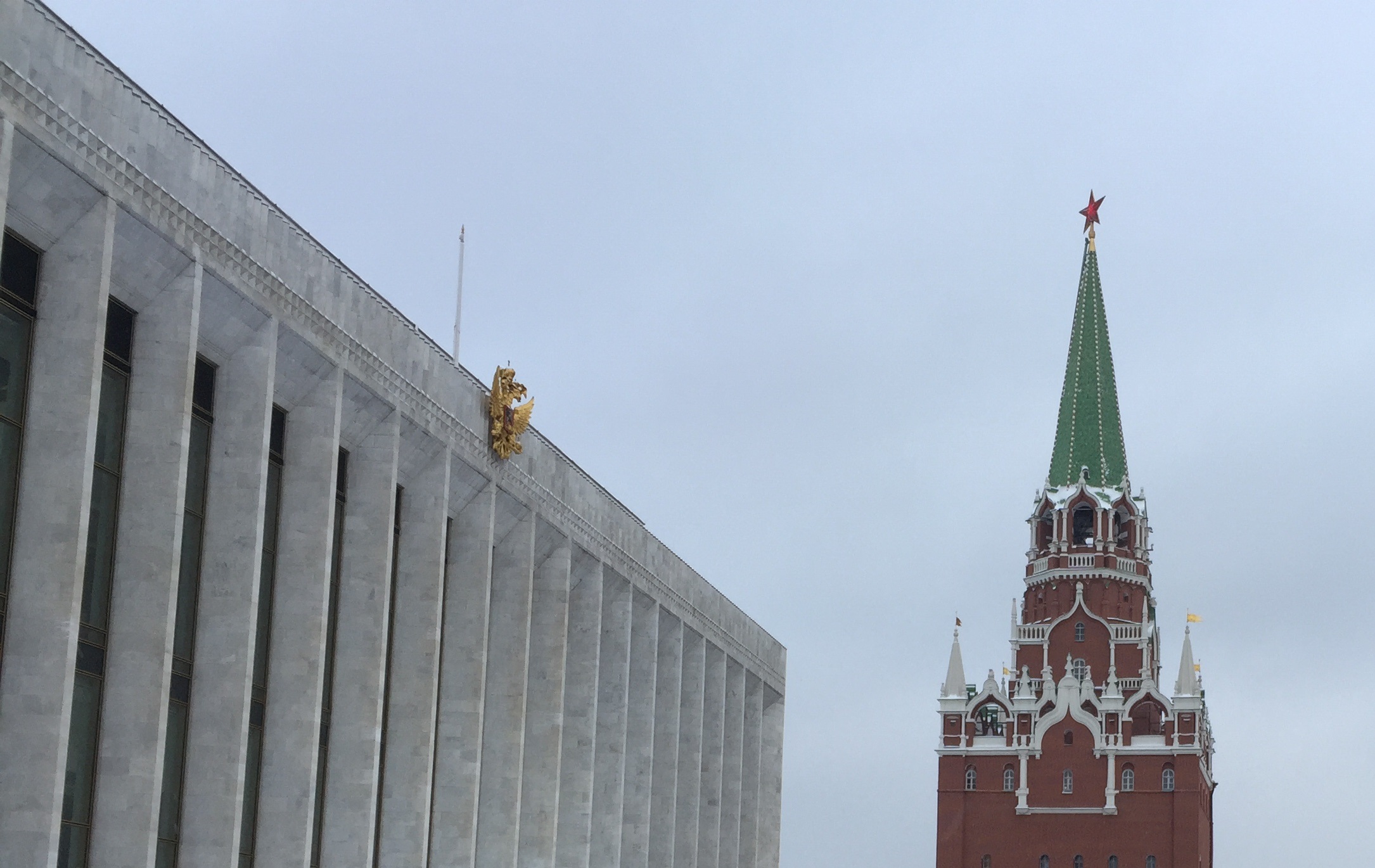 Dentro del Kremlin: el Palacio Estatal construido por el régimen soviético, ahora convertido en sala de conciertos y adornado con el águila bicéfala rusa (izquierda), junto a una de las columnas de la muralla medieval, con una estrella comunista en su punta