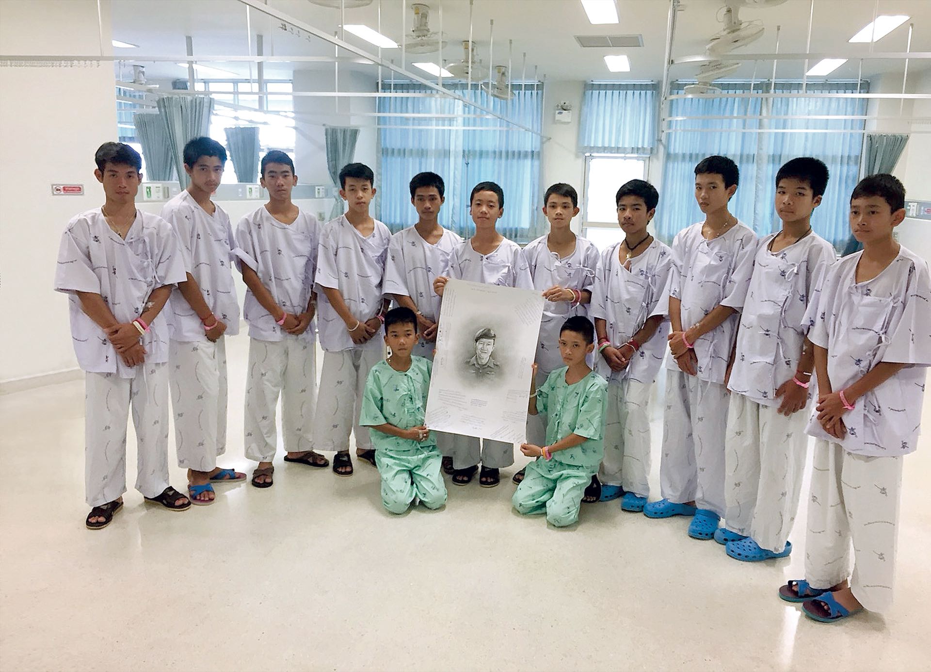 Los 12 niños y el entrenador rescatados en Tailandia tras pasar semanas atrapados en una cueva rinden un tributo al buzo fallecido durante el operativo, el 15 de julio, en el Hospital Chiang Rai Prachanukroh