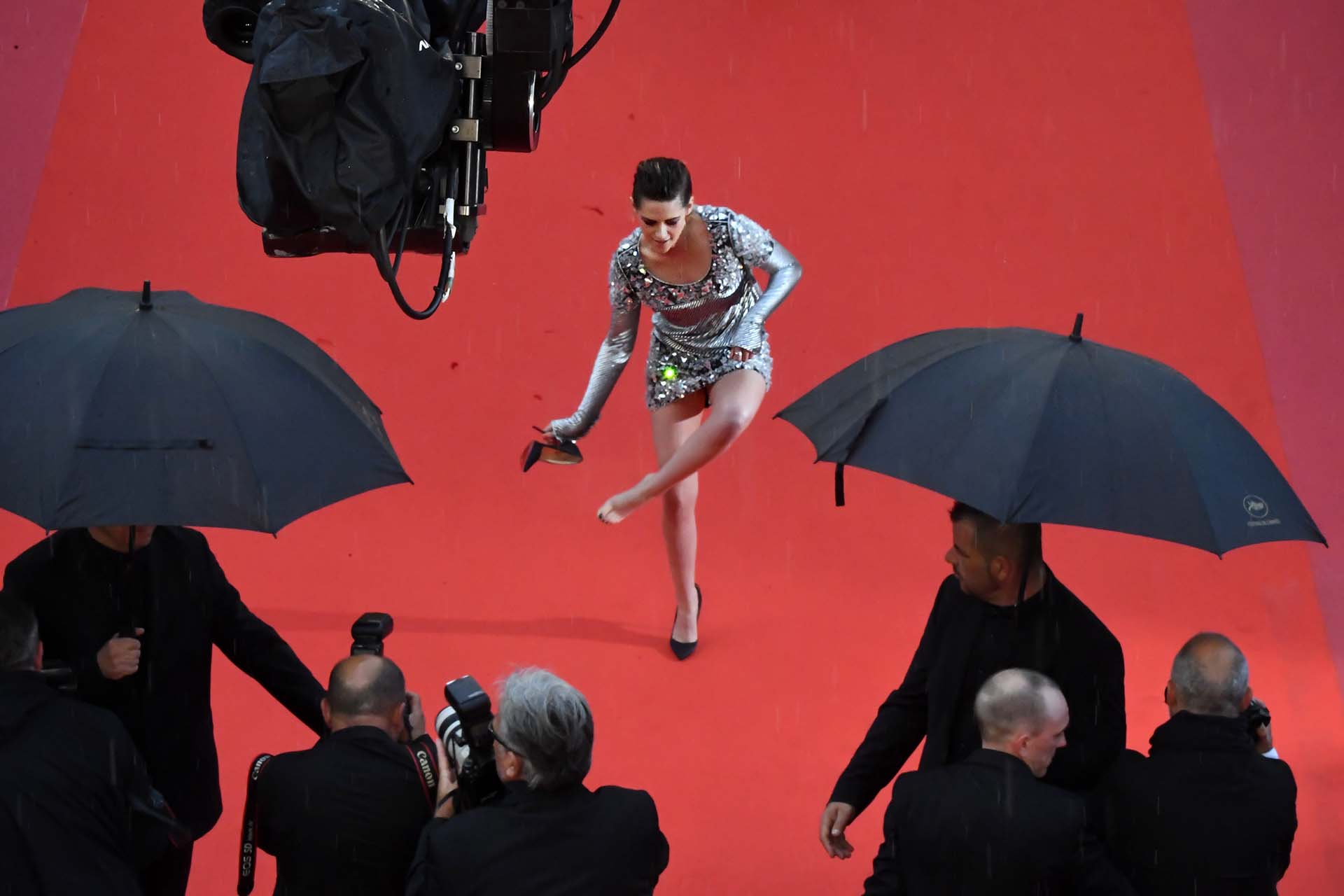 La actriz estadounidense Kristen Stewart se quita un zapato en la alfombra roja al llegar a la 71.ª edición del festival de Cannes el 14 de mayo