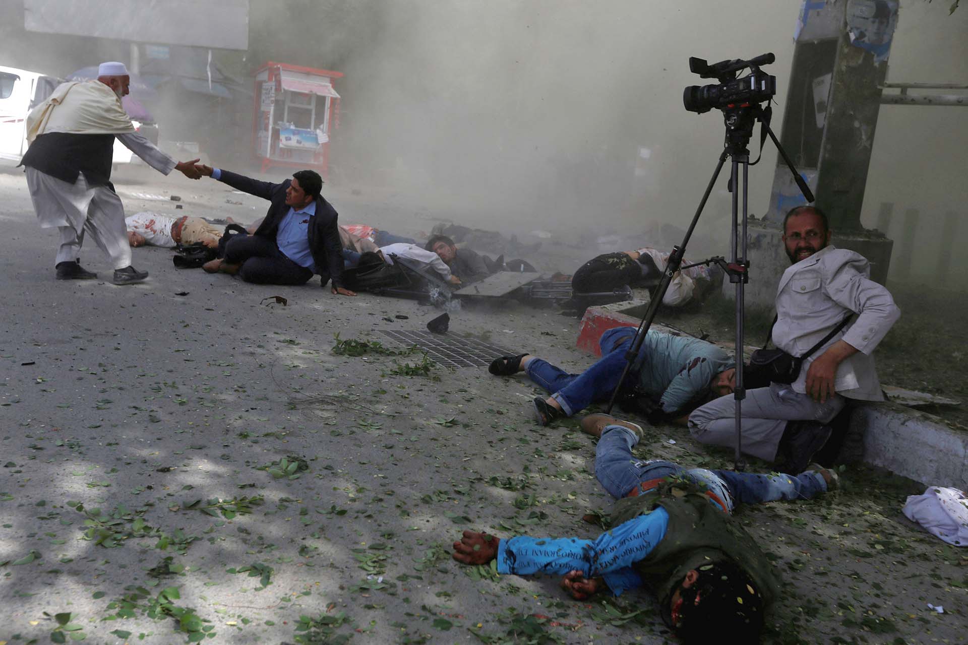 Periodistas afganos después de dos atentados suicidas del Estado Islámico que dejaron 29 muertos en el centro de Kabul el 20 de abril