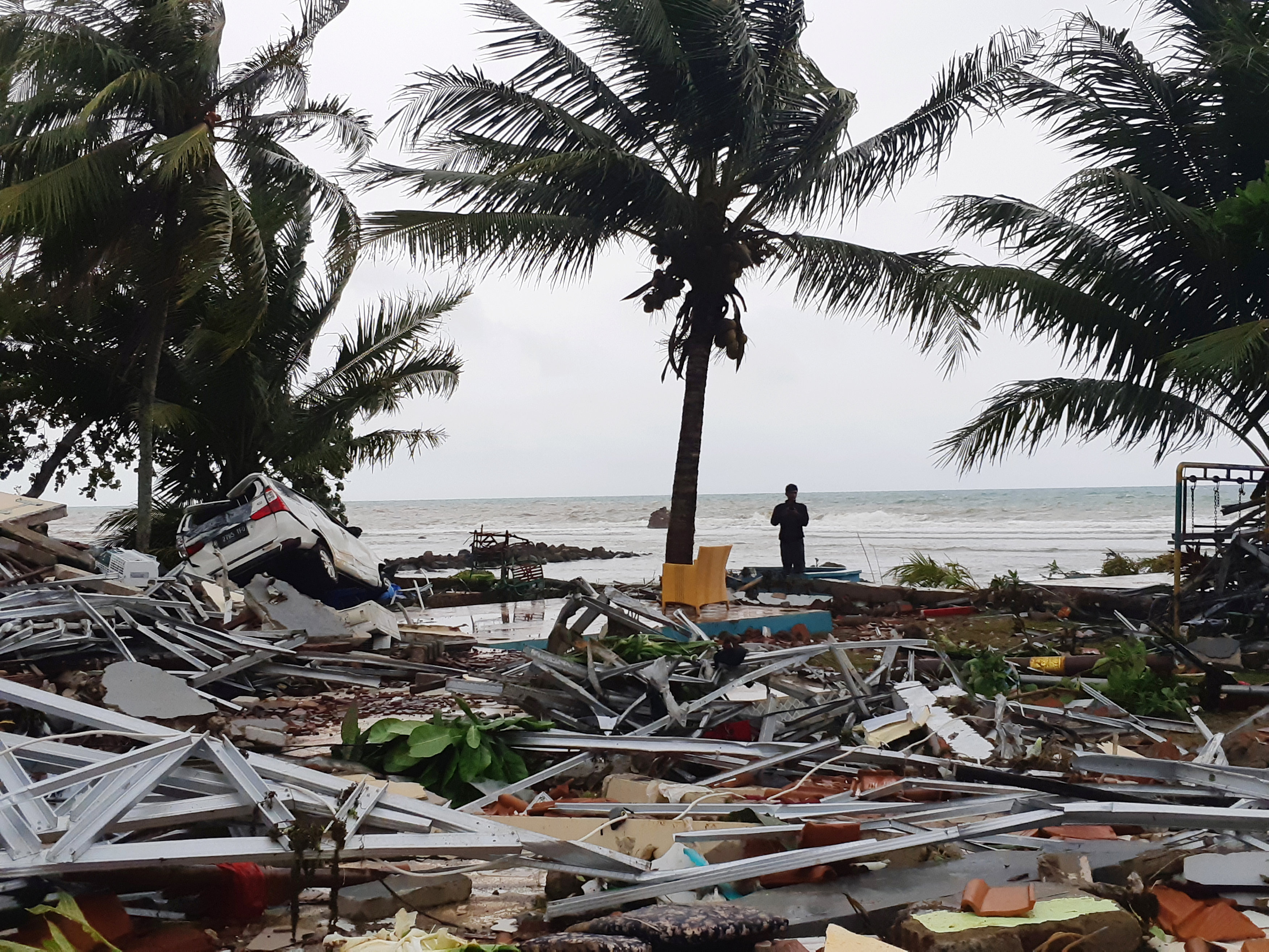 Una persona observa los destrozos desde la orilla