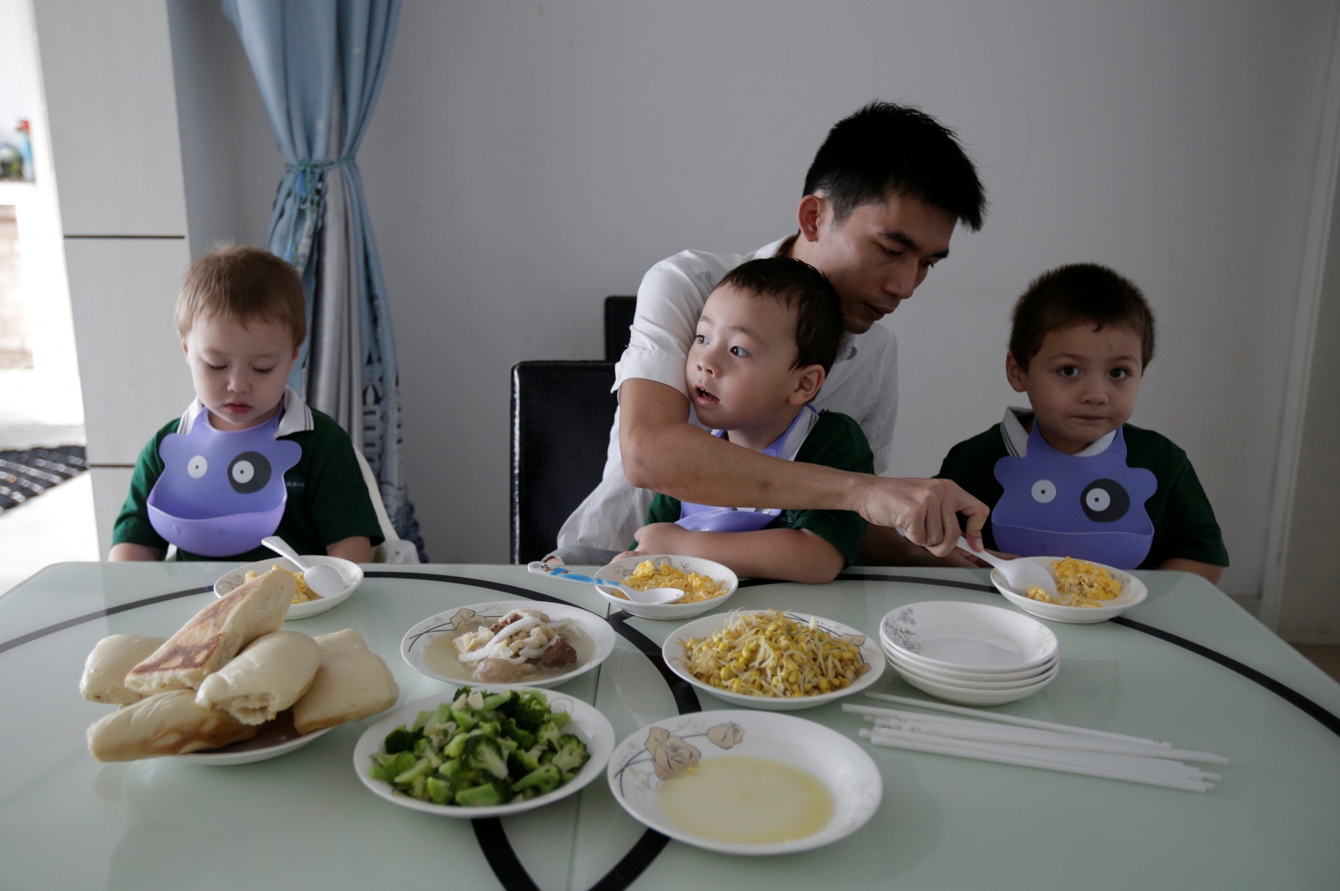 La pareja de An Hui, Ye Jianbin, ayuda a sus trillizos . An Zhiya, An Zhizhong y An Zhifei desayunan en su casa,