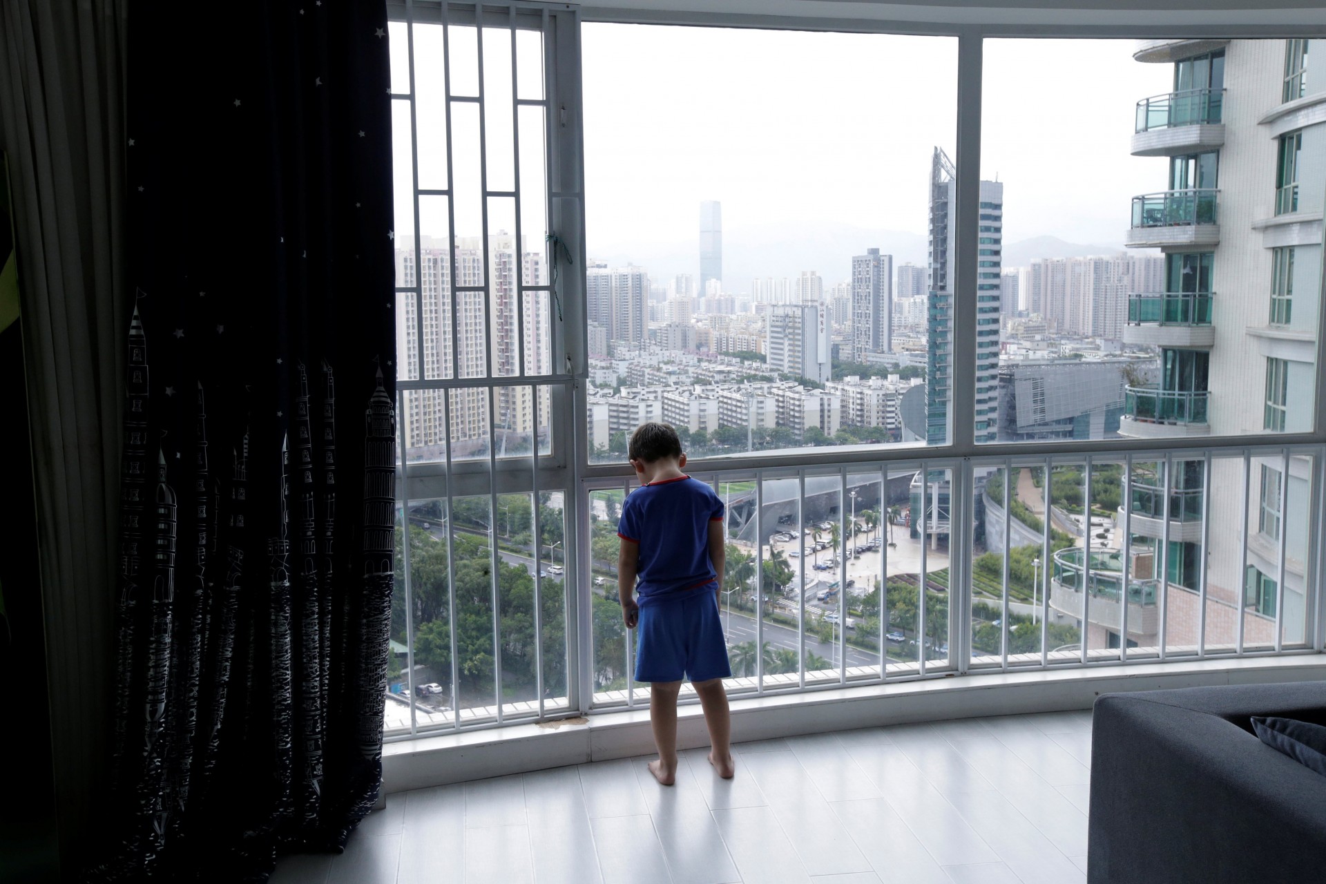 An Zhizhong, uno de los tres hijos de An Hui y Ye Jianbin, está parado junto a una ventana en su casa en Shenzhen, provincia de Guangdong, China, el 17 de septiembre de 2018.