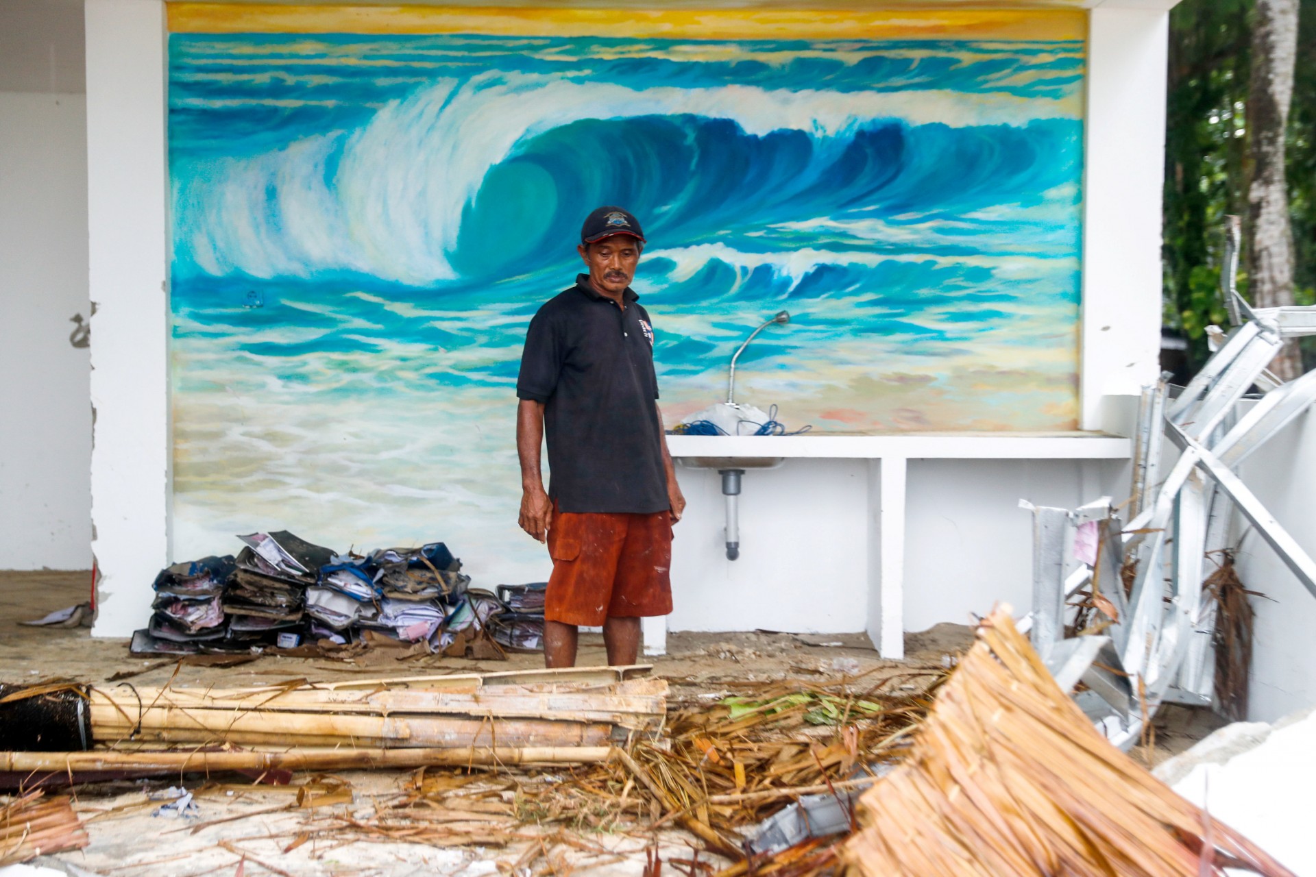 Un trabajador se para frente a un mural dentro de un bar en un complejo destruido que fue golpeado por un tsunami en Tanjung Lesung, provincia de Banten, Indonesia, Indonesia, 24 de diciembre de 2018.