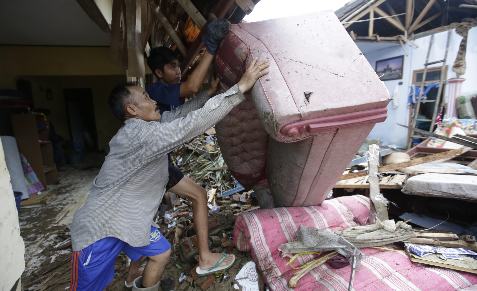 El residente local Alimin limpia los escombros de su casa luego del tsunami en Carita, Indonesia, el jueves 27 de diciembre de 2018.