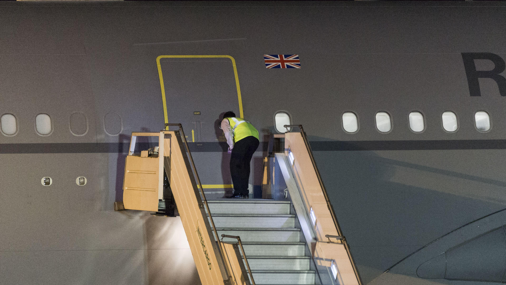 Un empleado del aeropuerto de Ezeiza espía por la mirilla del avión a la espera del descenso de la Primera Ministra de Reino Unido, Theresa May, para la reunión de G20 (Julieta Ferrario)