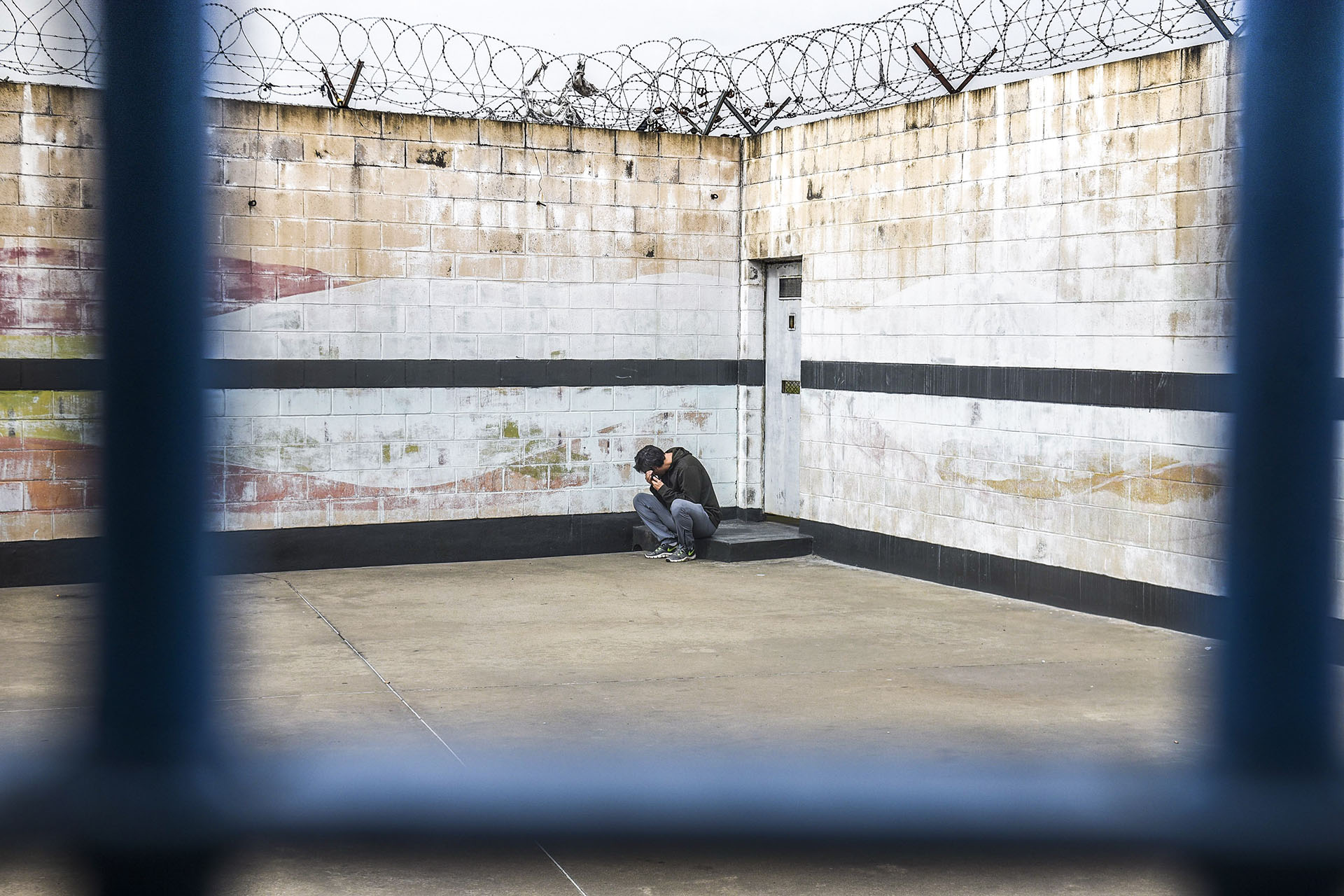 Un presidiario de la Unidad Penitenciaria 48 de San Martín intenta hablar por teléfono (Guille Llamos)