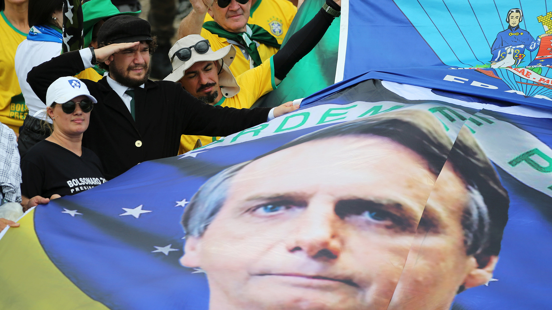 Los seguidores sostienen una bandera con el rostro de Bolsonaro (REUTERS/Sergio Moraes)