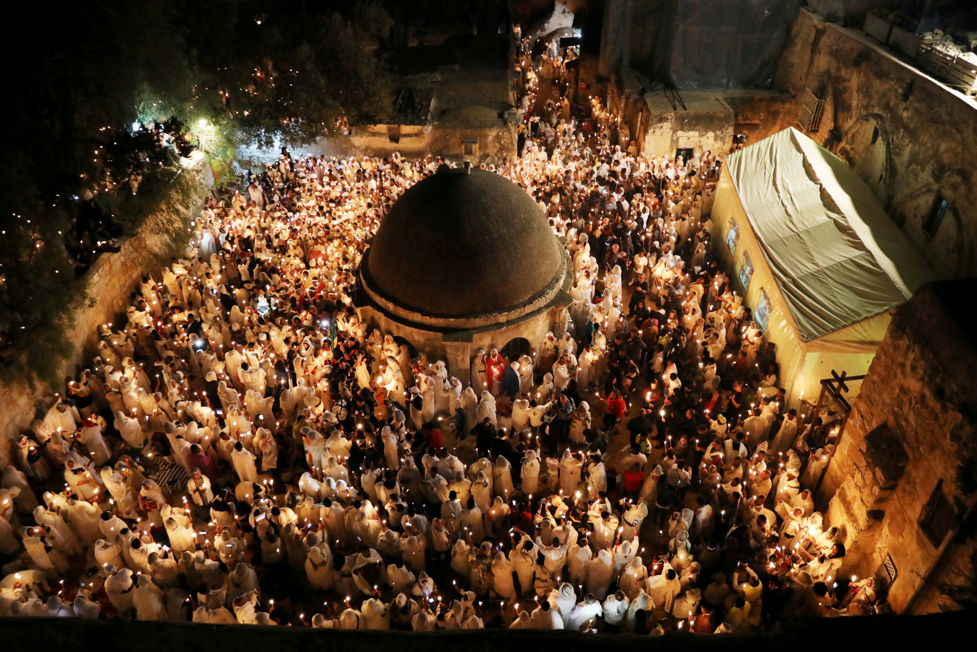 Los adoradores ortodoxos etíopes sostienen con velas durante la ceremonia del Fuego Sagrado en la sección etíope de la Iglesia del Santo Sepulcro en la ciudad vieja de Jerusalén, el 7 de abril de 2018.