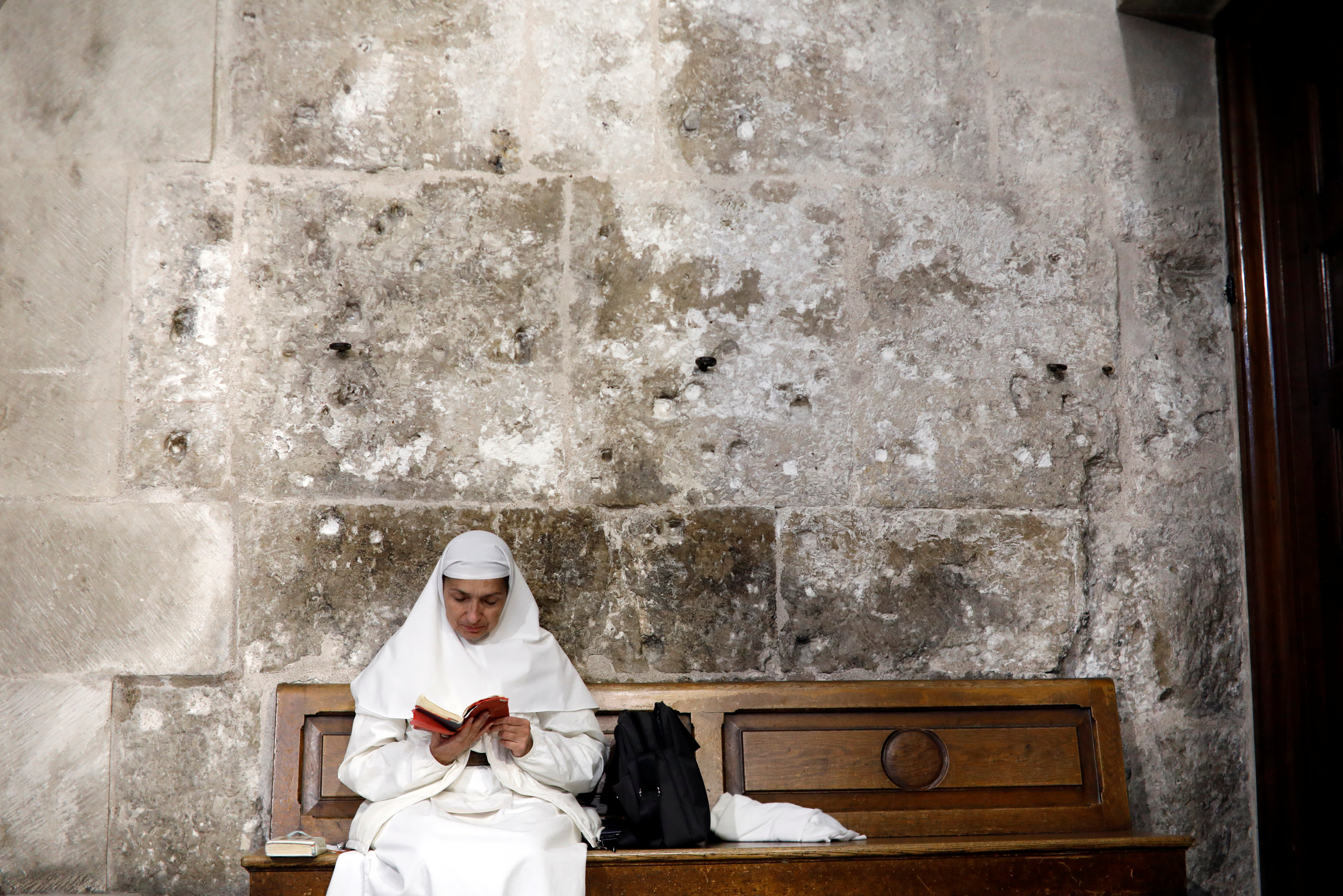 Una monja se sienta en un banco dentro de la Iglesia del Santo Sepulcro en la ciudad vieja de Jerusalén, 17 de noviembre de 2018.