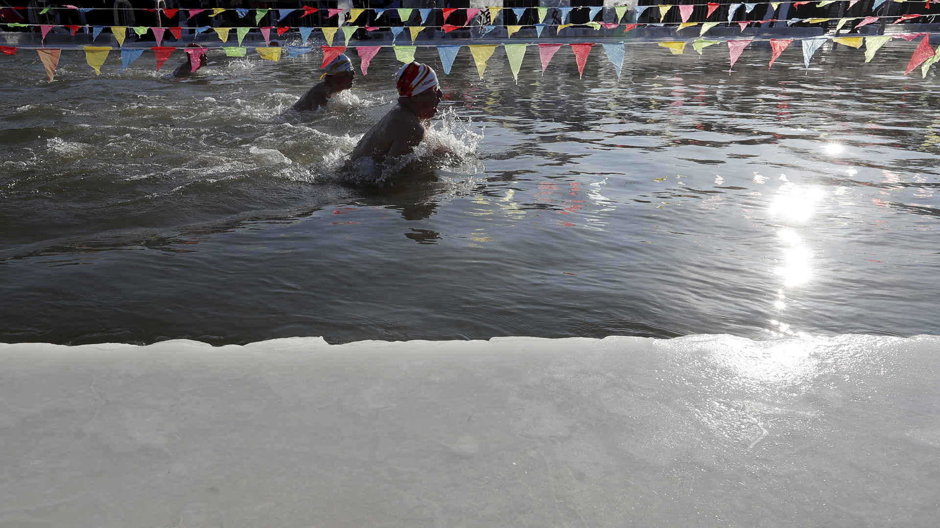 Los participantes nadan en una piscina excavada en el congelado río Songhua para la competencia anual de natación en Harbin. (Reuters)