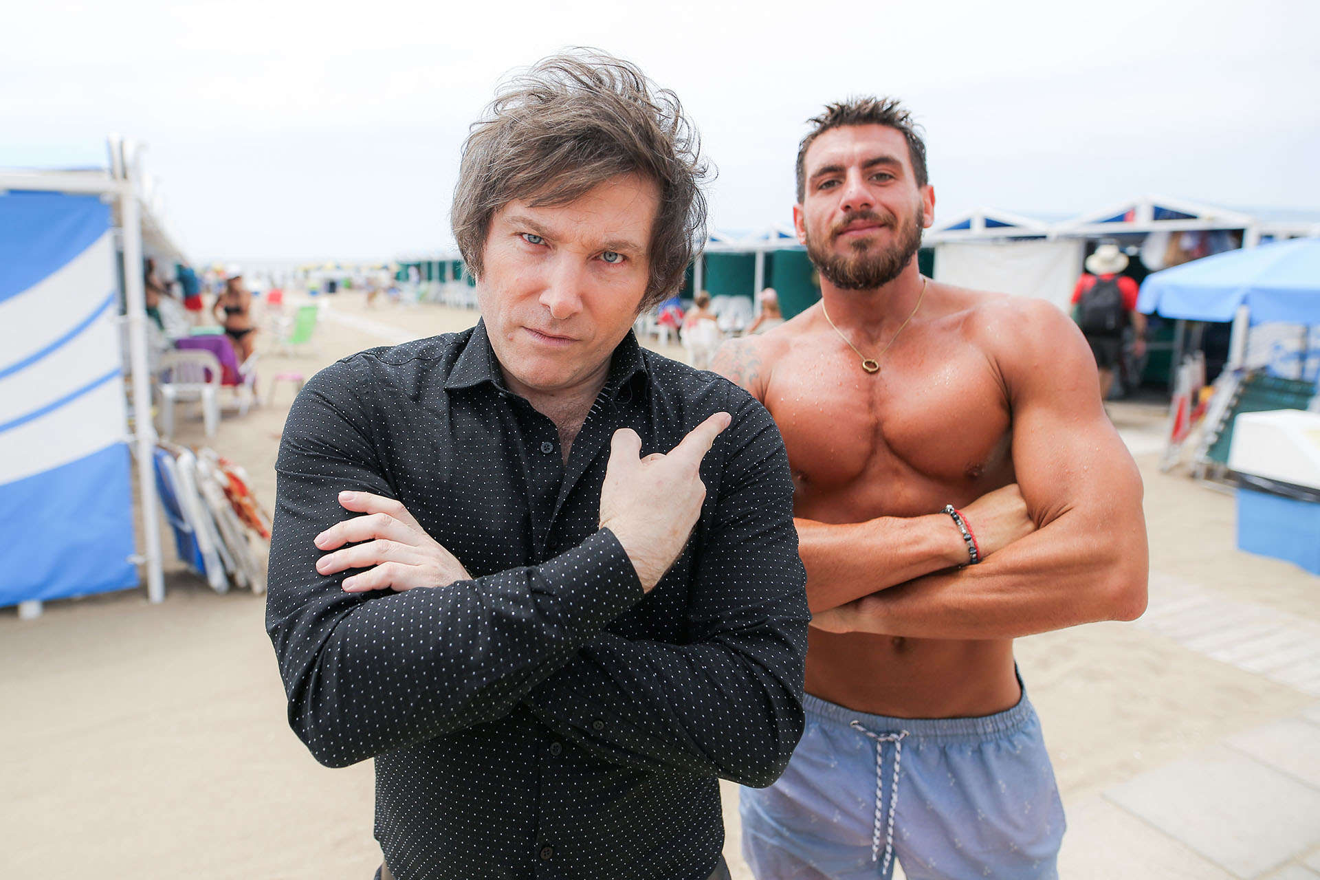 ¡¿Y ese quién es?! ¿El hombre que baja a la playa con camisa oscura y pelo cuidadosamente enmarañado? ¡No! Claro que no… Ese es el economista Javier Milei, cuya opinión toma cada vez más fuerza. Nos referimos al fortachón -justamente- que deja verse detrás suyo. Pues bien, es un admirador del economista, quien pasó por Mar del Plata para hacer una función de su obra teatral. Y por lo visto, en lo que no ahorra Milei es en popularidad (Foto: Christian Heit)