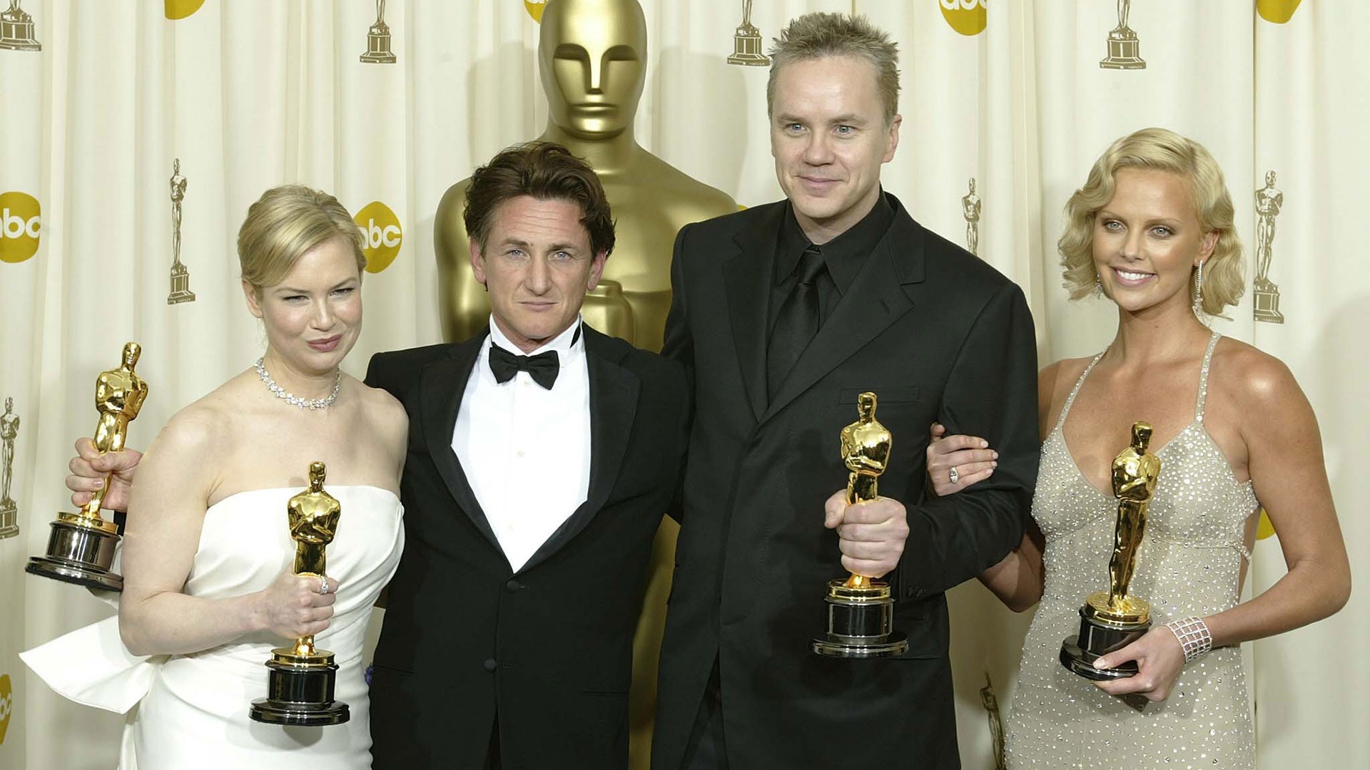 Con Renée Zellweger, Sean Penn y Charlize Theron luego de ganar su Oscar por su papel en “Río Místico” (AFP)