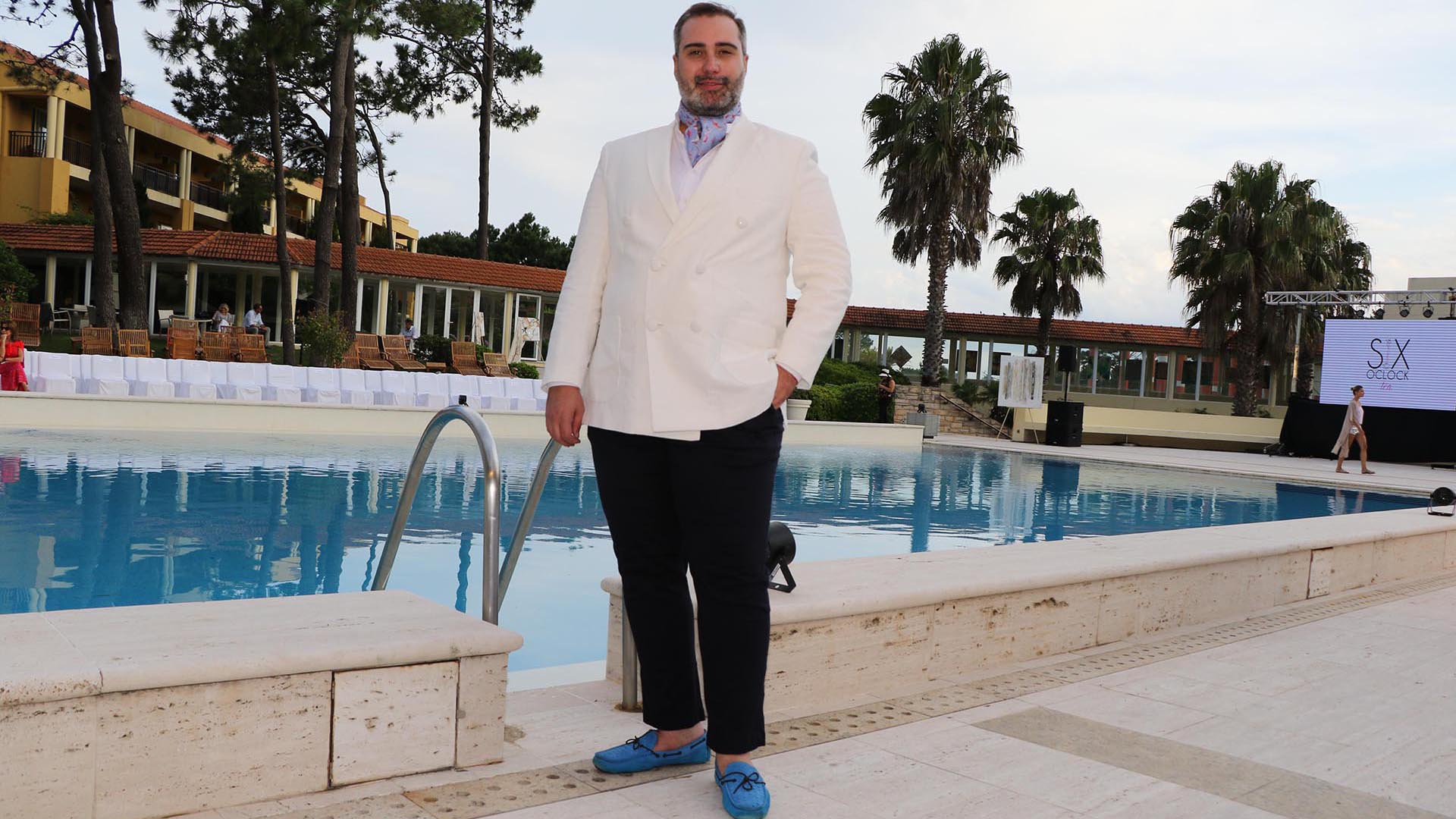 Saco cruzado en blanco, camisa lila, pañuelo a tono, pantalón negro y mocasines celestes. El look elegante de Carlos Burró en Punta