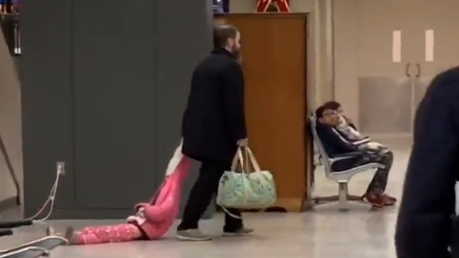 Un hombre arrastra a su hija por el aeropuerto en Virginia (Captura de pantalla)