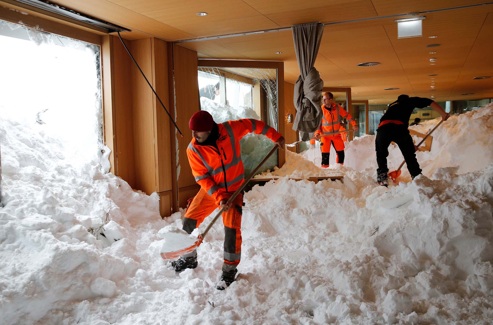Trabajadores intentan remover la nieve de un restaurante tras una avalancha en Suiza (REUTERS/Arnd Wiegmann)