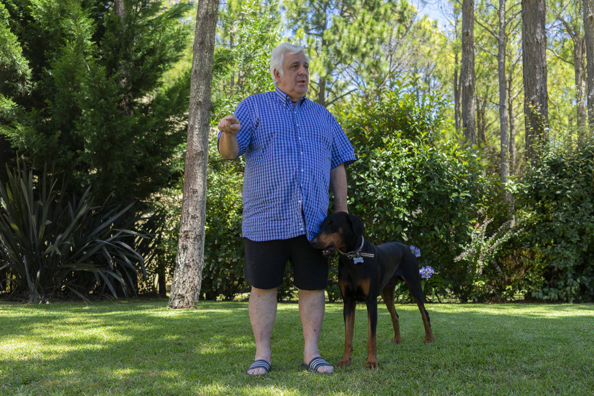 Samid junto a su perro “Negro”, en el jardín de su casa pinamarense (Mariano Imperial)