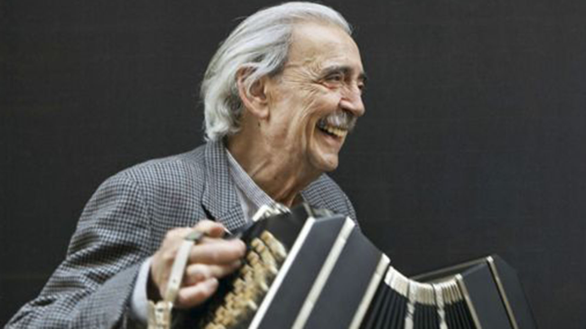 Gelman tocando el bandoneón, una de sus pasiones, retratado por el gran fotógrafo argentino Daniel Mordzinski