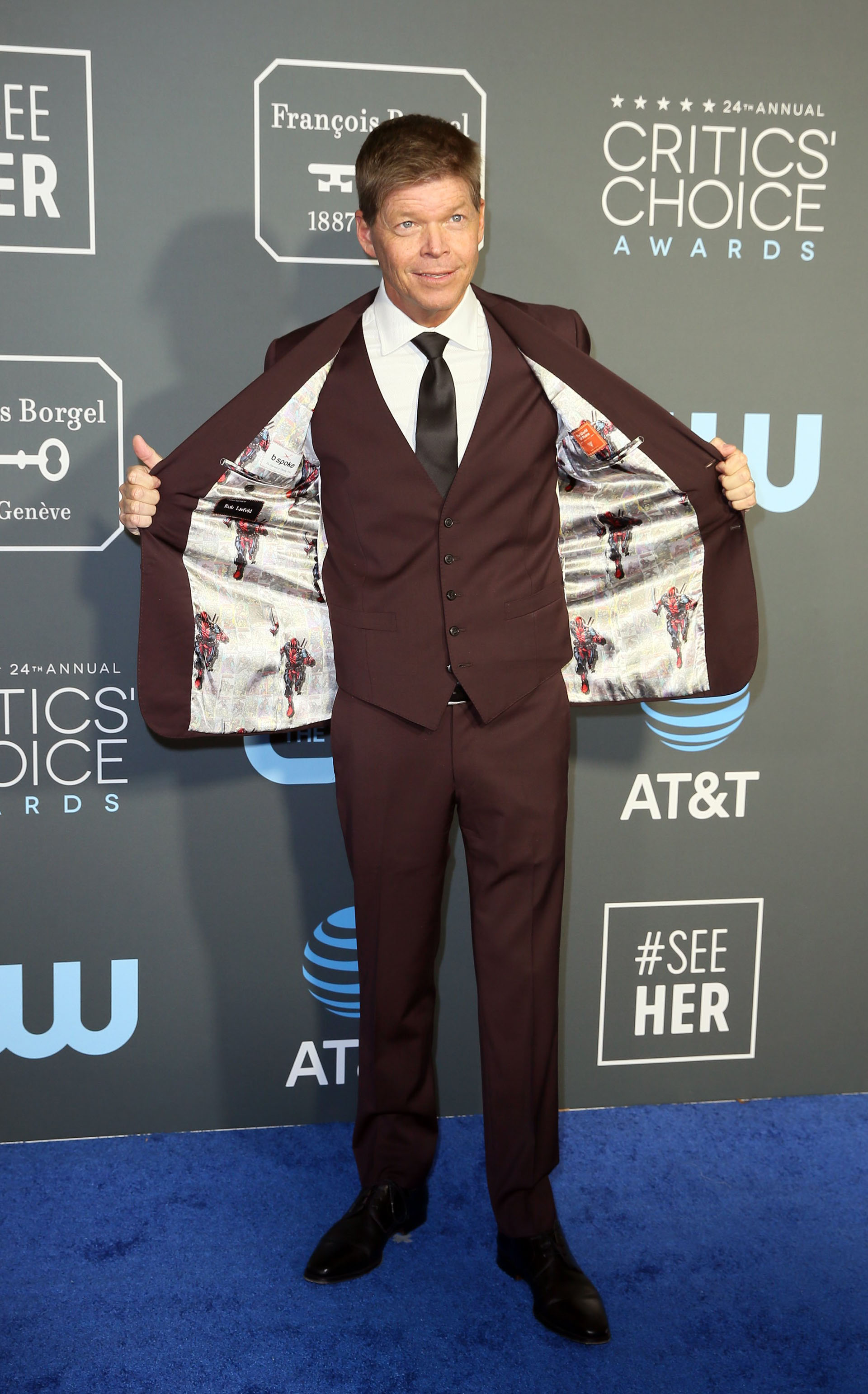 Rob Liefeld eligió un esmoquin de tres piezas en color marrón con corbata y zapatos negros. ¿El detalle extravagante? El forro de Spiderman de su saco