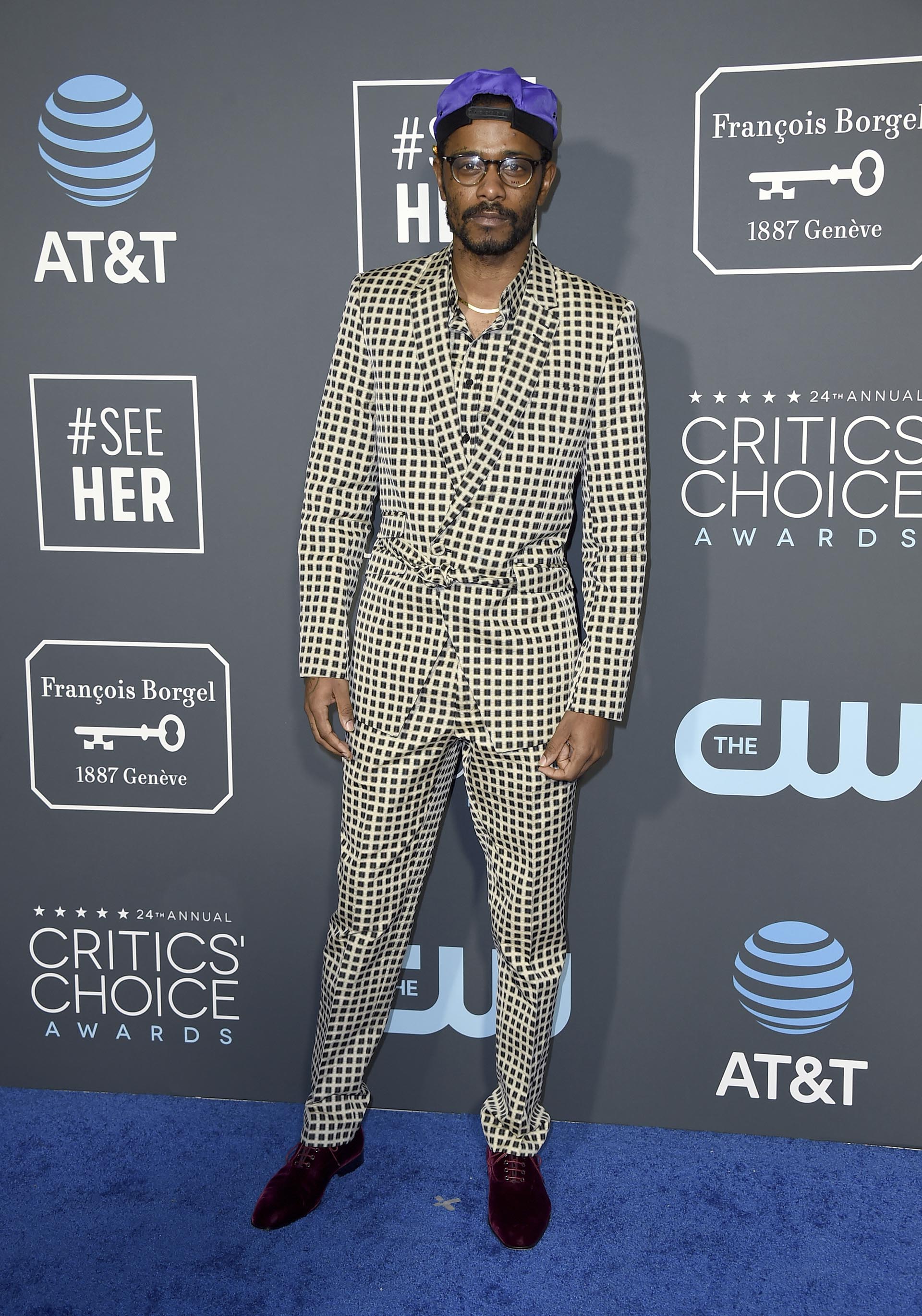 Lakeith Stanfield sorprendió en la blue carpet con un esmoquin cuadrillé en offwhite y negro. La camisa, el saco y el pantalón, todos con el mismo estampado. El detalle aún más fashionista, sus zapatos acordonados rojos de chiffón