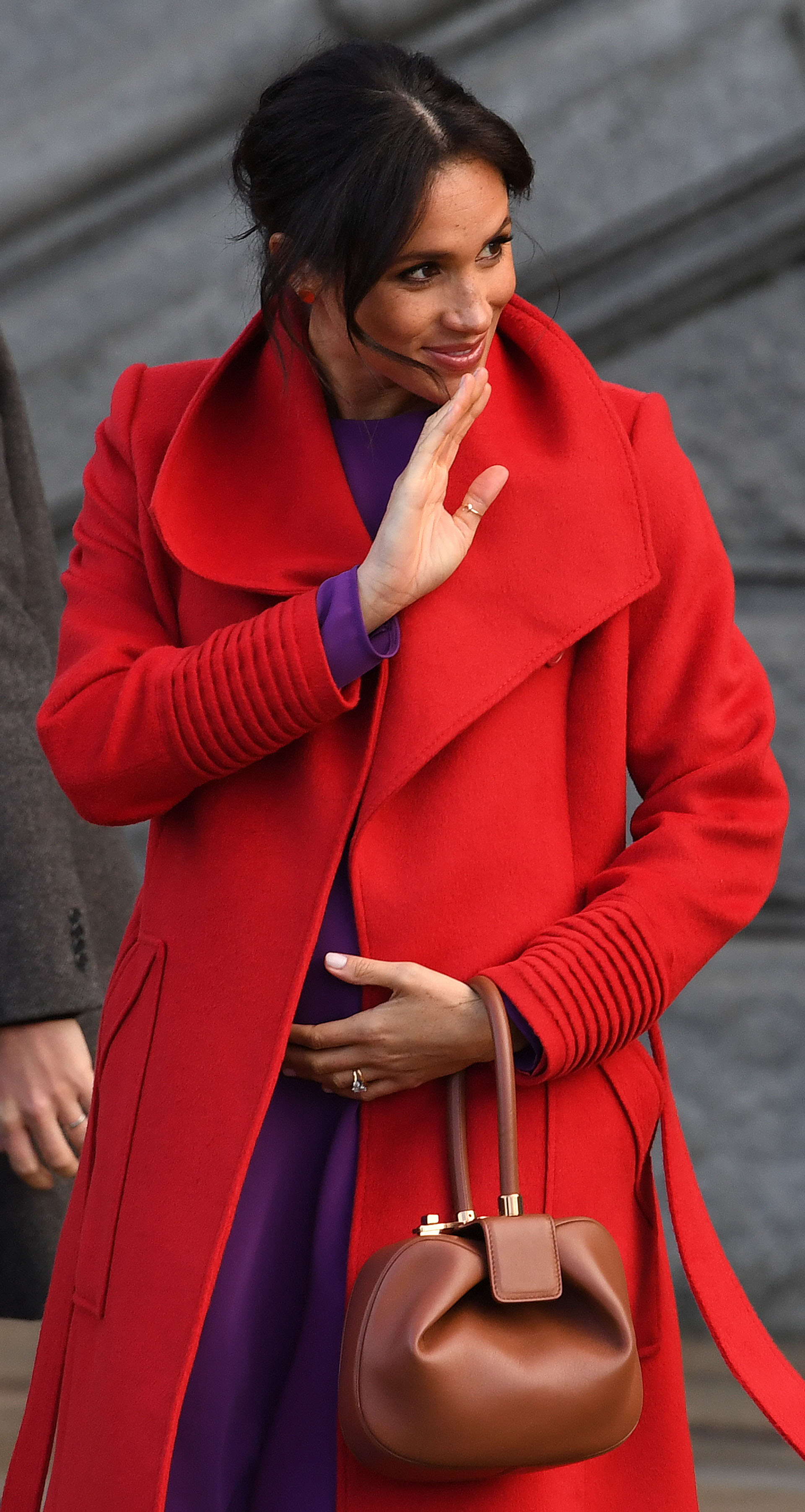 La duquesa de Sussex, lució su embarazo en la visita oficial al Birkenhead junto al príncipe Harry, y optó por un vestido violeta low cost de 50 dólares y un tapado rojo de Sentaler. Su look color block recordó mucho a dos outfits del mismo tono usados por la mamá del príncipe Harry (AFP)