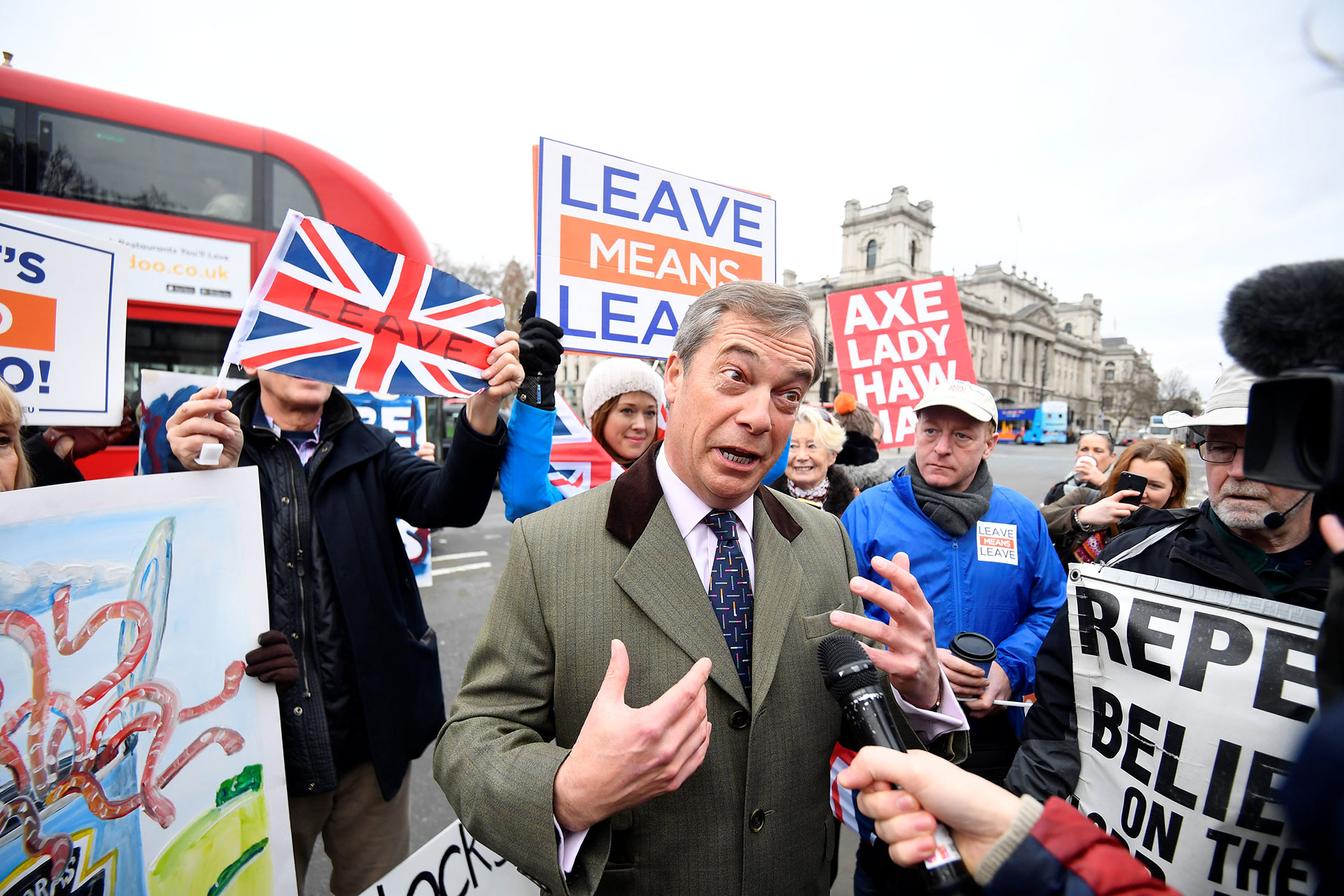 El ex líder del UKIP Nigel Farage habla a los medios de comunicación mientras los manifestantes a favor y en contra del proyecto de ley se manifiestan frente a la sede del Parlamento en Londres, Gran Bretaña, el 15 de enero de 2019. (Reuters)