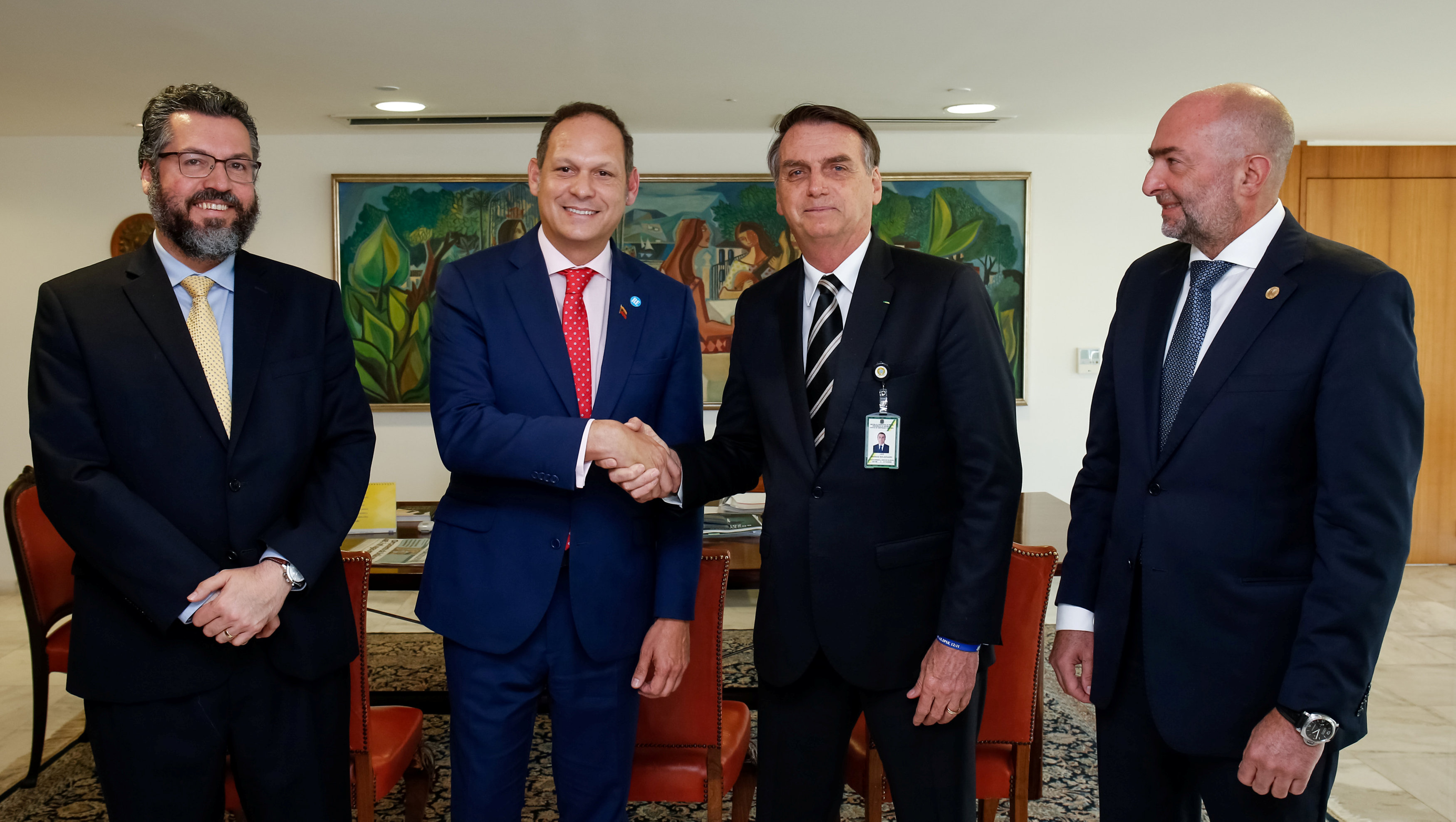Jair Bolsonaro estrecha la mano del presidente del Tribunal Supremo venezolano en el exilio Miguel Angel Martin, junto al canciller Ernesto Araujo (izquierda) y al representante de la OEA Gustavo Cinosi durante su encuentro en Brasilia (Alan Santos/Presidencia de Brasil via Reuters)