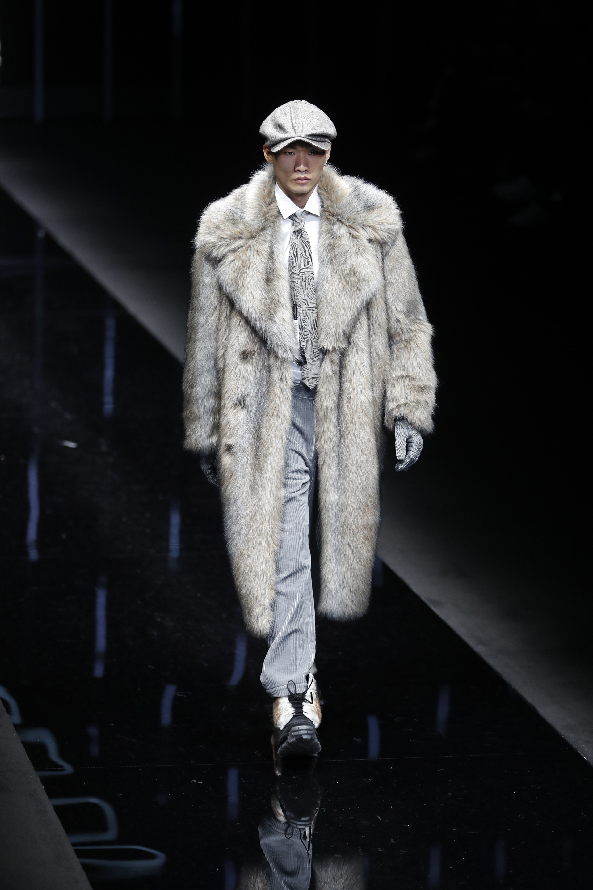 Sobretodo de piel, pantalón sastrero, corbata con estampado geométrico, camisa blanca, guantes de cuero y borceguíes con piel, el exclusivo diseño de la colección otoño-invierno 2019-2020 de Emporio Armani en Milán