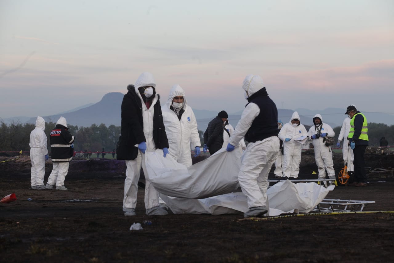 Peritos forenses levantan los cuerpos de los fallecidos en la explosión de la toma clandestina de Hidalgo. (Foto: Cuartoscuro)