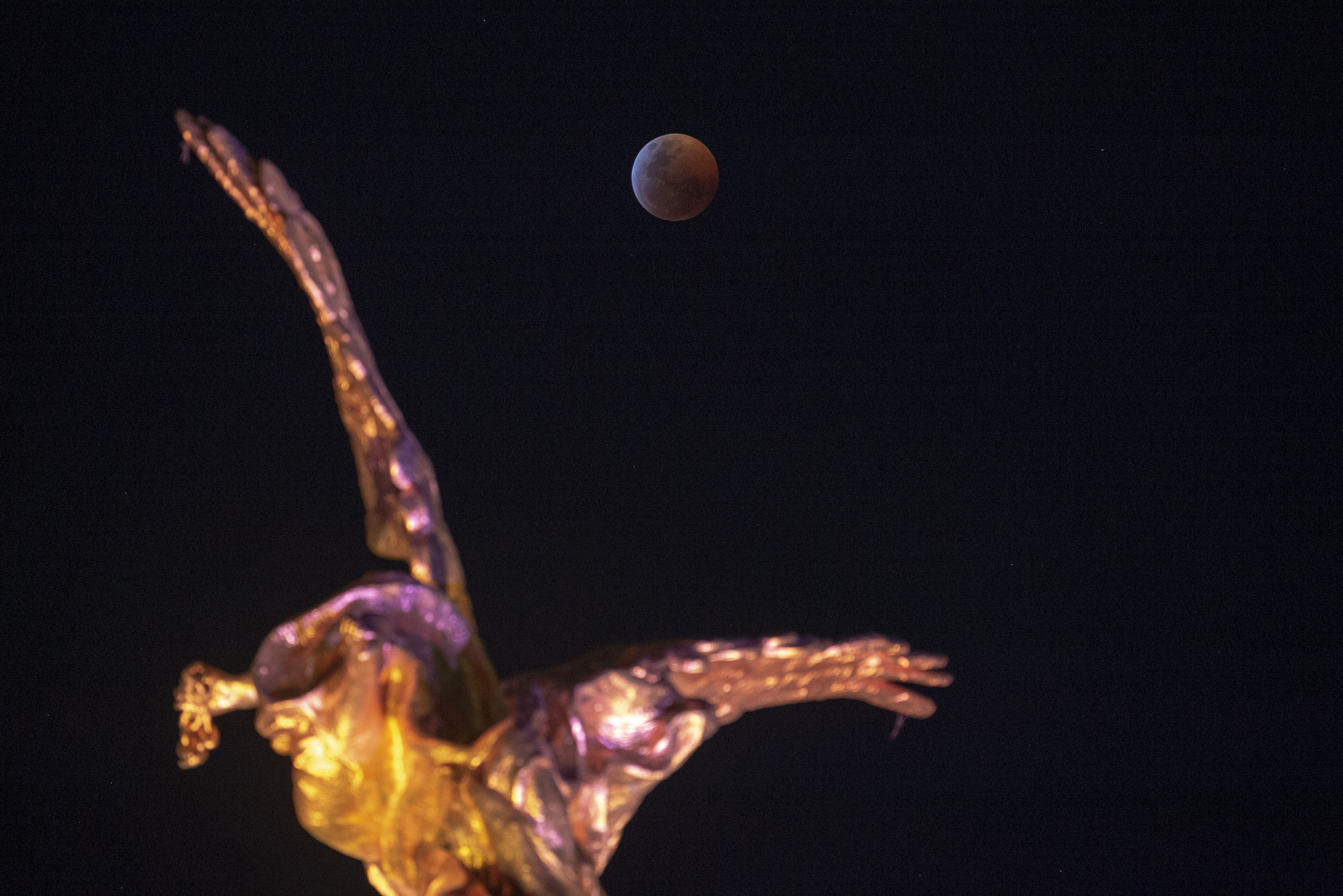 La luna de sangre sobre el Ángel de la Independencia en Ciudad de México (ALFREDO ESTRELLA / AFP)