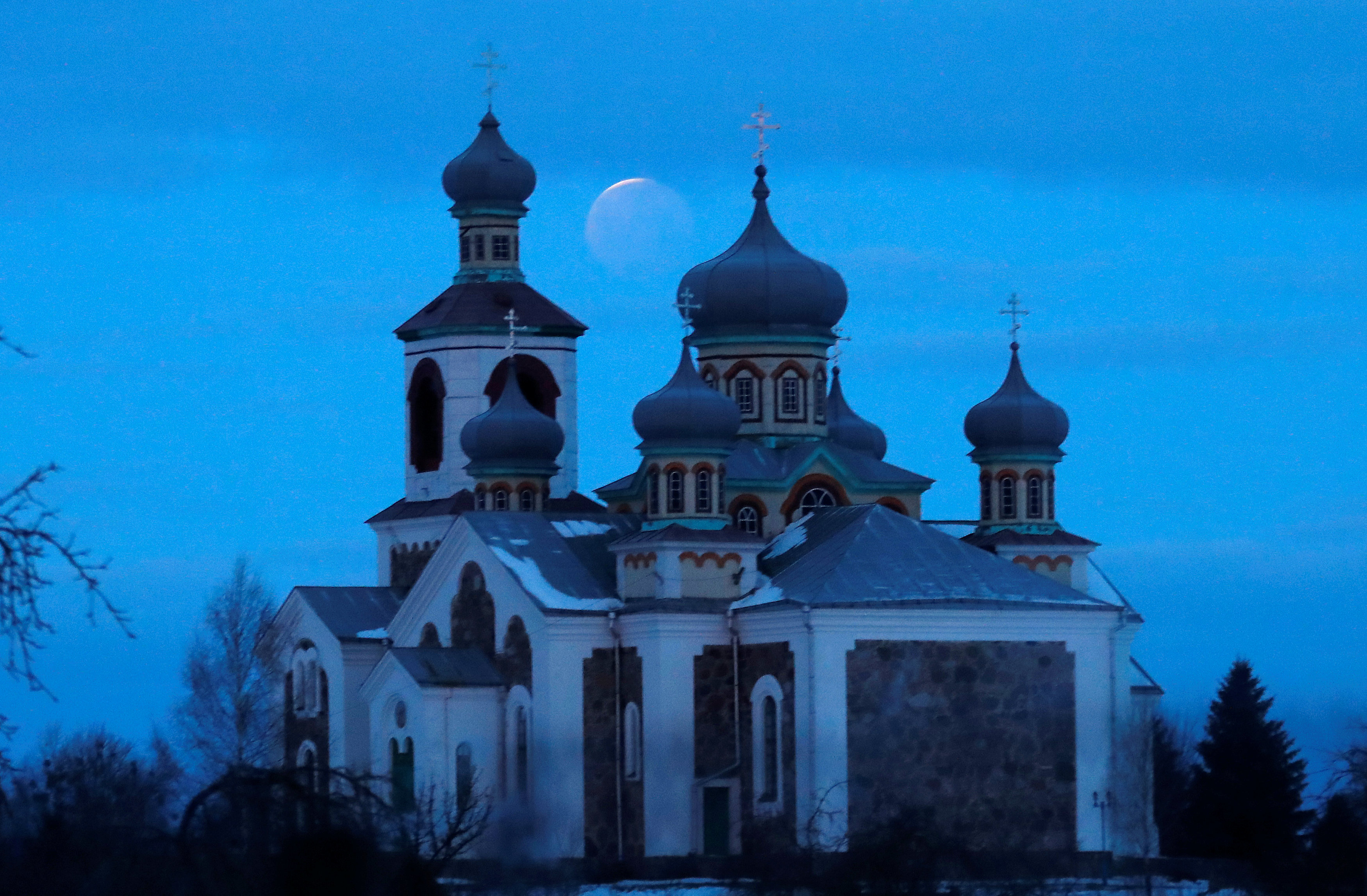 La luna roja detrás de una iglesia ortodoxa en Turets, Bielorrusia. (REUTERS/Vasily Fedosenko)