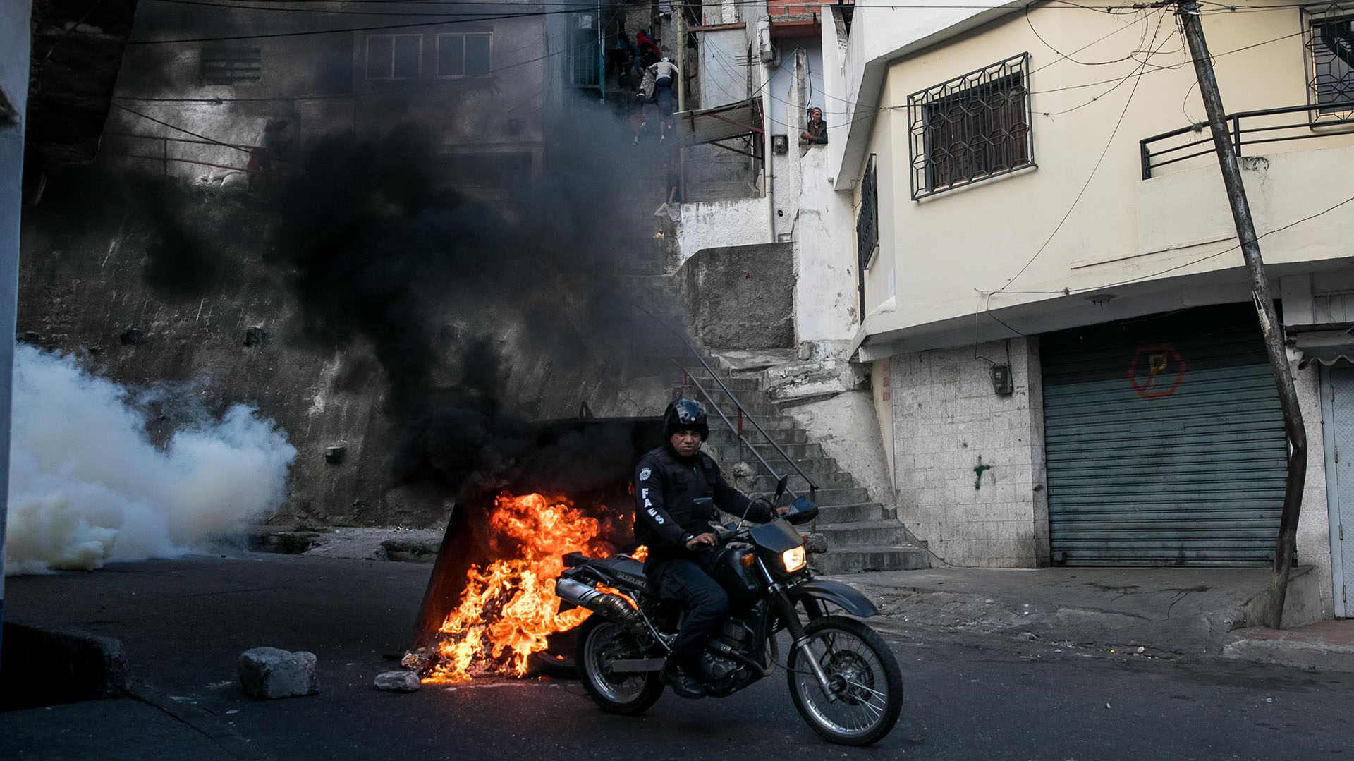 Un miembro de Fuerzas de Acciones Especiales (FAES) se moviliza en su moto cerca a la manifestación