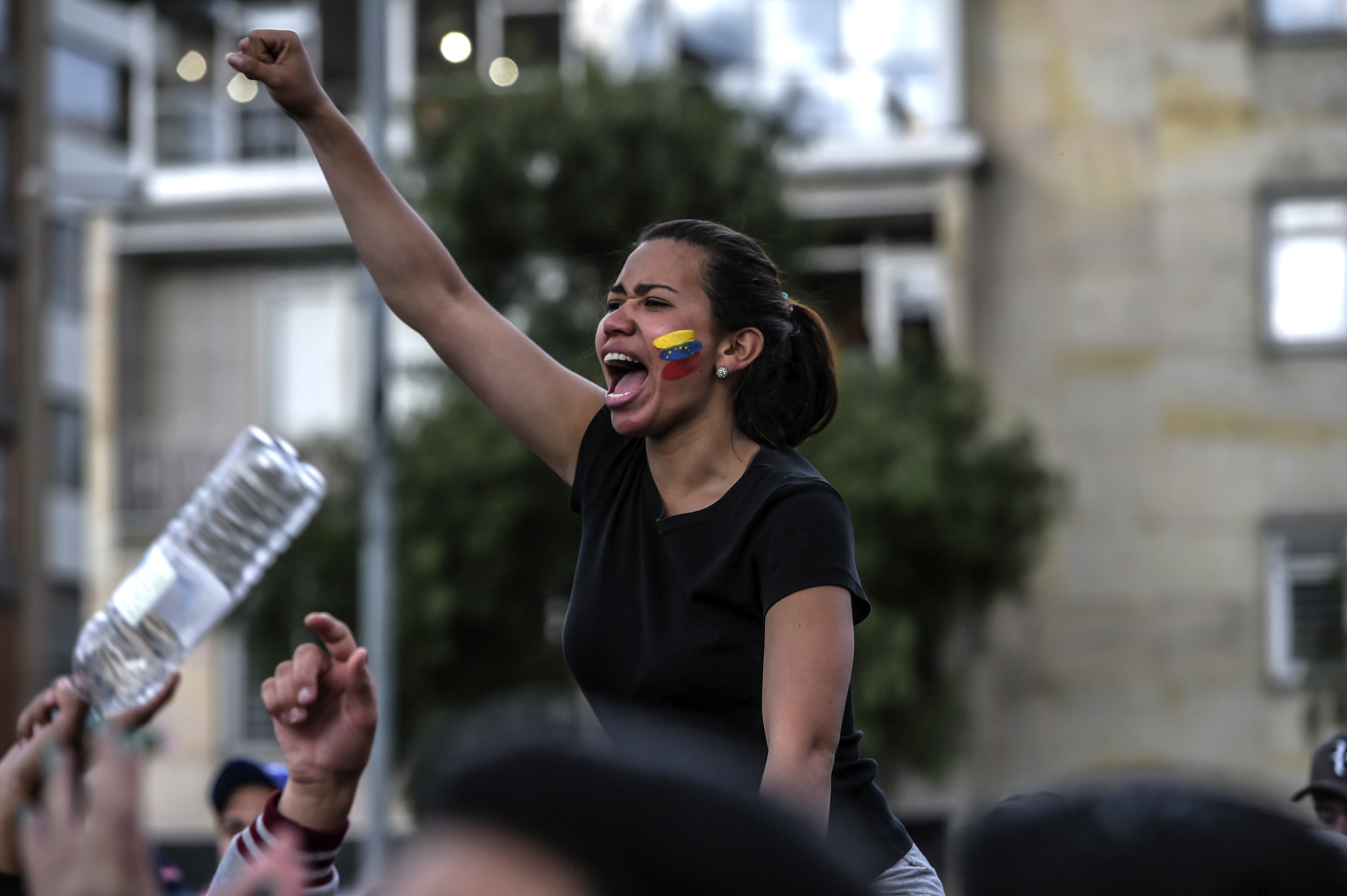 Un joven venezolana protesta contra la dictadura chavista en Bogotá. (Photo by Juan BARRETO / AFP)