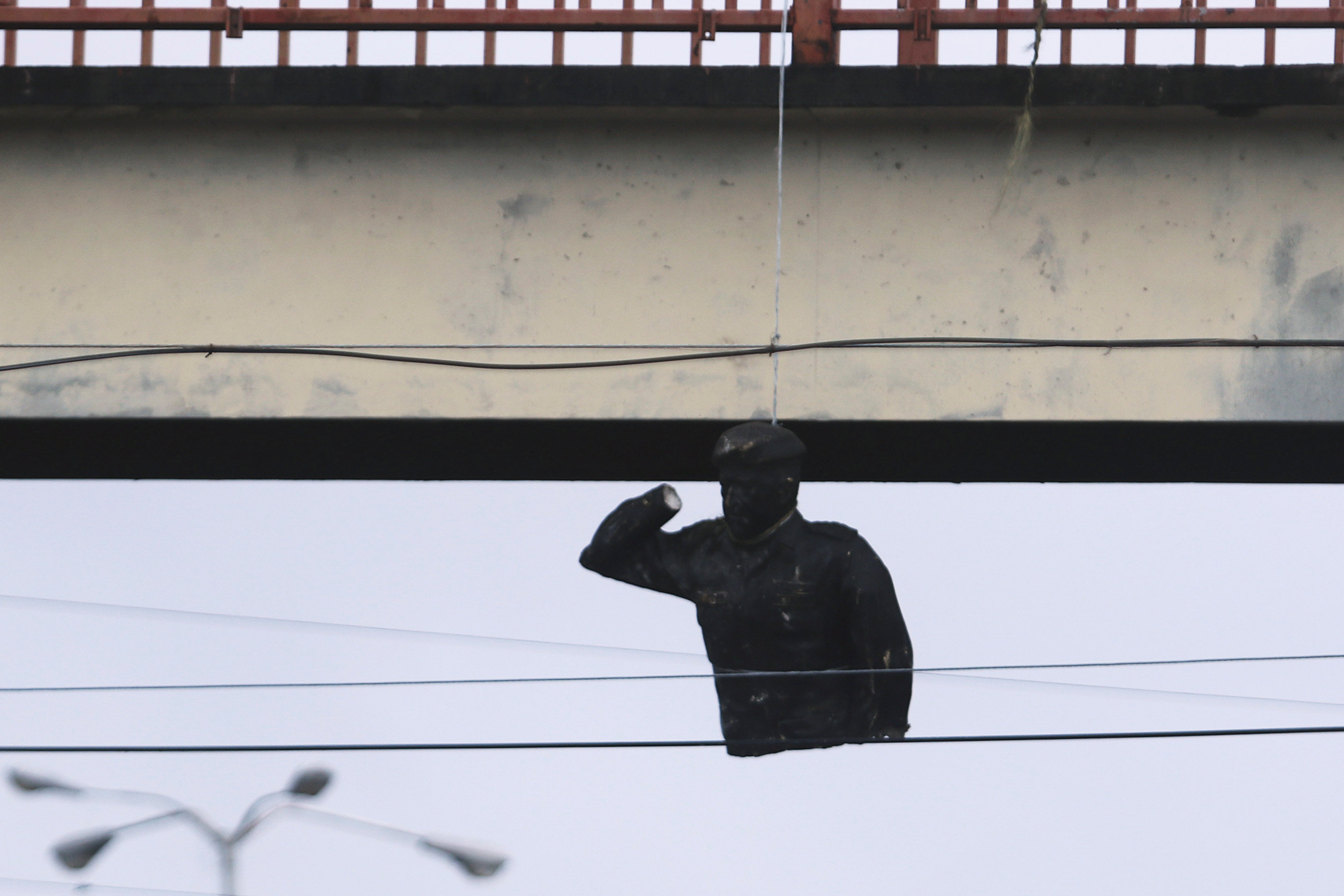 Una estatua destruida de Hugo Chávez es colgada de un puente en San Félix, Venezuela. (REUTERS/William Urdaneta)